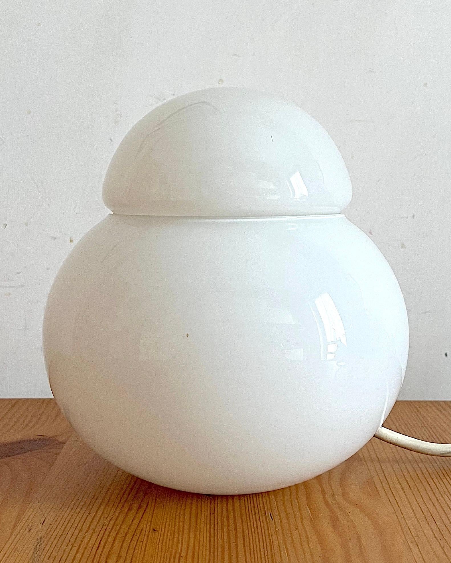 Daruma was designed by Sergio Asti in 1968 and produced by Candle, now Fontana Arte. The piece is made up of two white blown glasses. This object is exhibited at the Museum of Modern Art in New York thanks to its smooth and rigorous shape. This