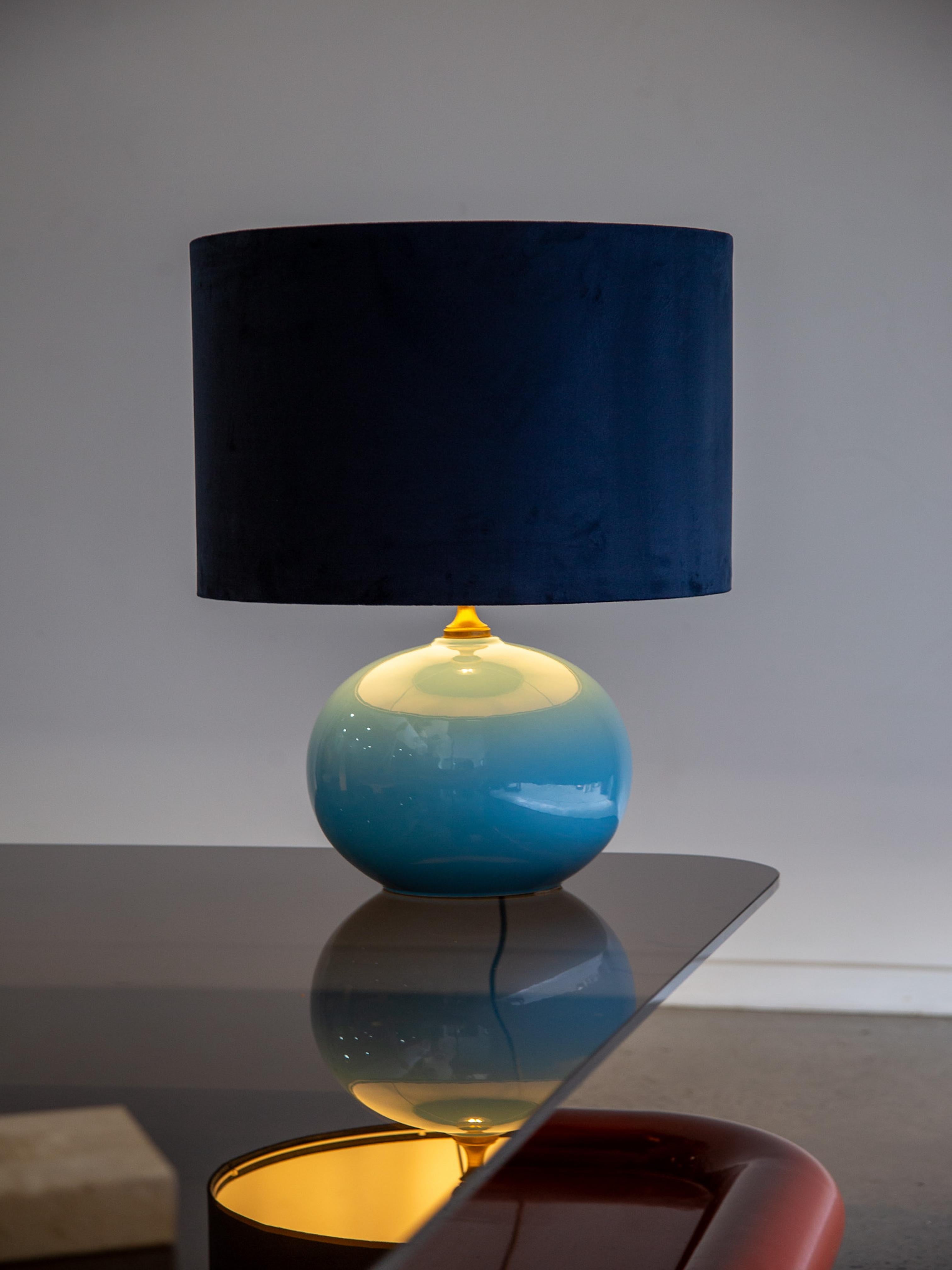 Esta lámpara de sobremesa Italia, una sofisticada pieza de Società Porcellane Artistiche (SPA), captura la elegancia del diseño italiano de mediados de siglo con su forma atrevida y su rica paleta de colores. La base esférica está esmaltada en un