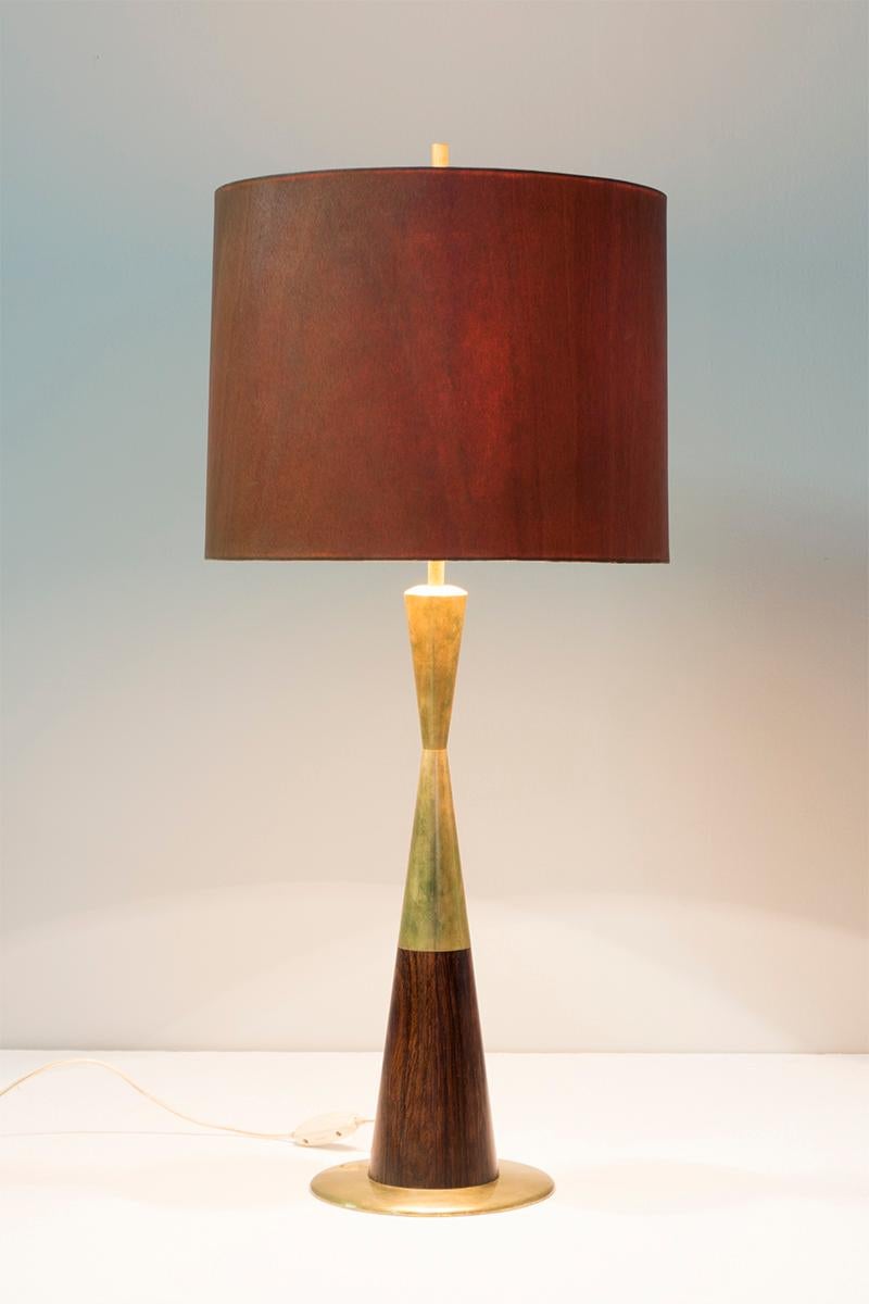 Questa elegante lampada da tavolo, modello n. '8058', è realizzata con un supporto in ottone e palissandro massiccio. Il paralume è realizzato in compensato e impiallacciatura Tanganica ed è stato progettato da Stilnovo nel 1965.