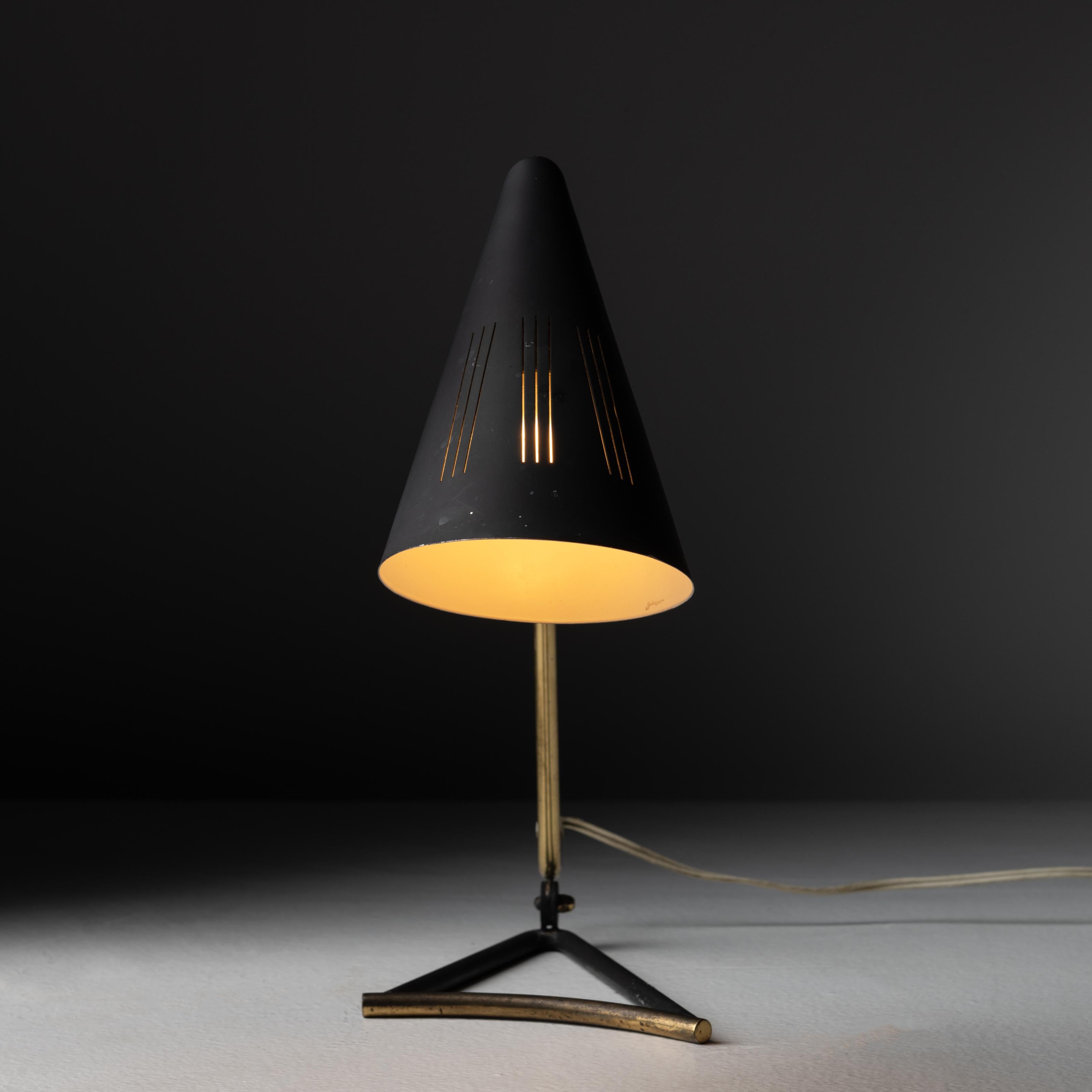 Table lamp by Svend Aage Holm Sørensen. Designed and manufactured in Denmark, circa 1950. Elegant and minimal curved brass table lamp with black enameled shade, with three parallel line die-cuts for additional light diffusion. This lamp hold one E14