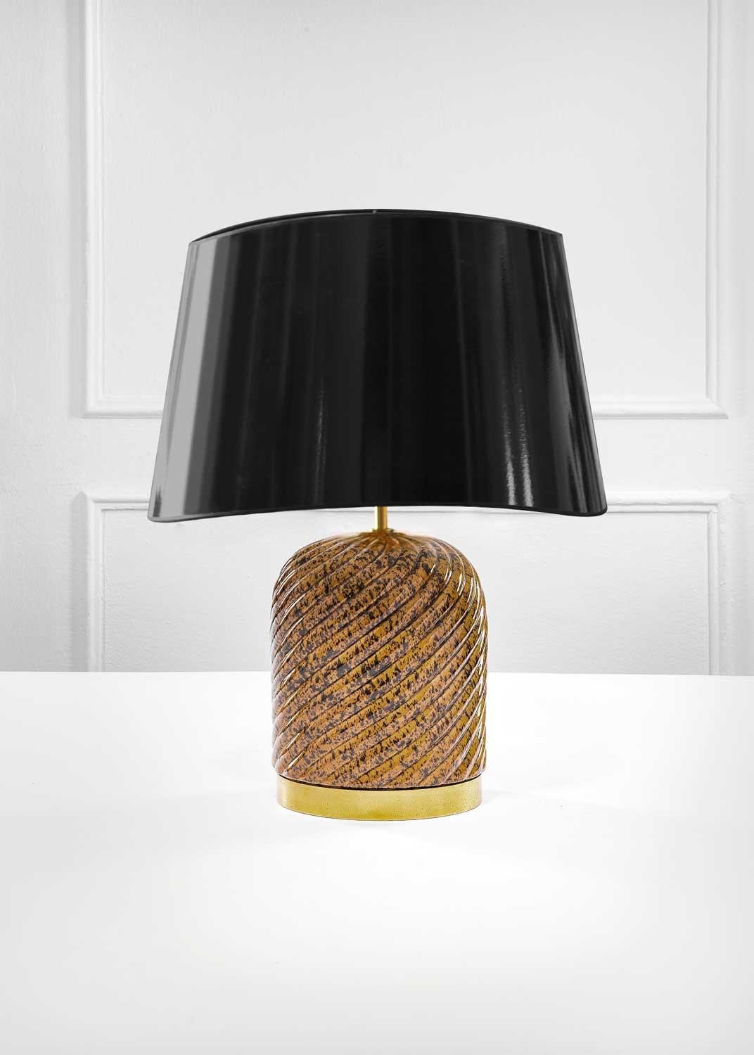 TOMMASO BARBI TABLE LAMP 1970
Table lamp by Tommaso Barbi in glazed ceramic and brass. Complete with lampshade in vinyl. Italian production 1970. 
This vintage table lamp serves as a striking focal point in any room, whether placed on a bedside