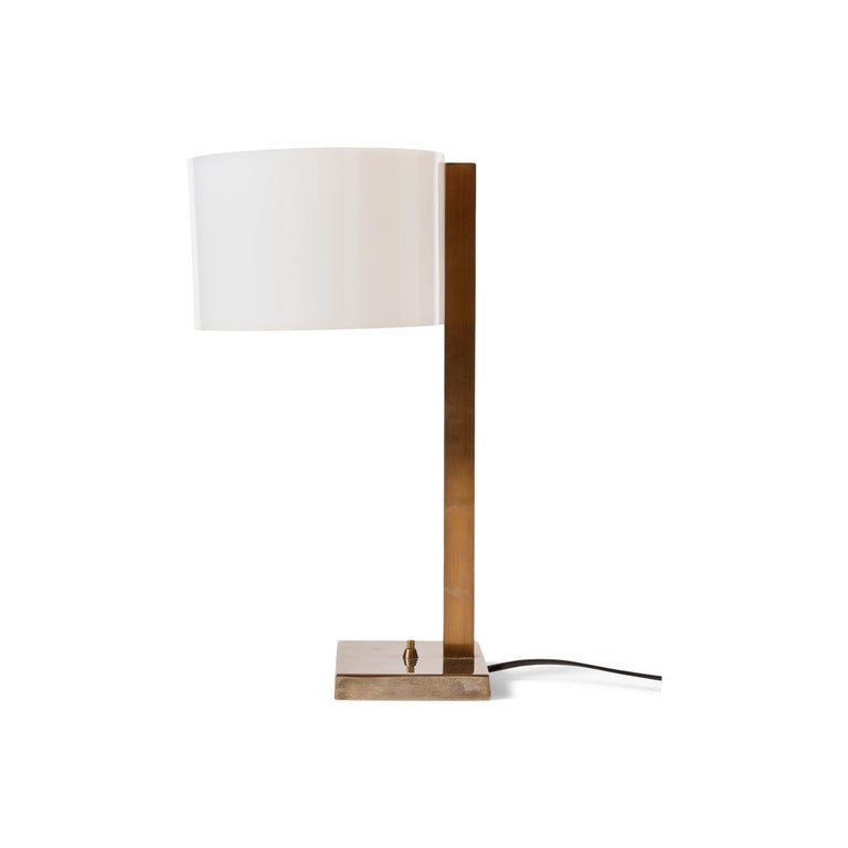 A table lamp in darkened brass with a spun acrylic shade.