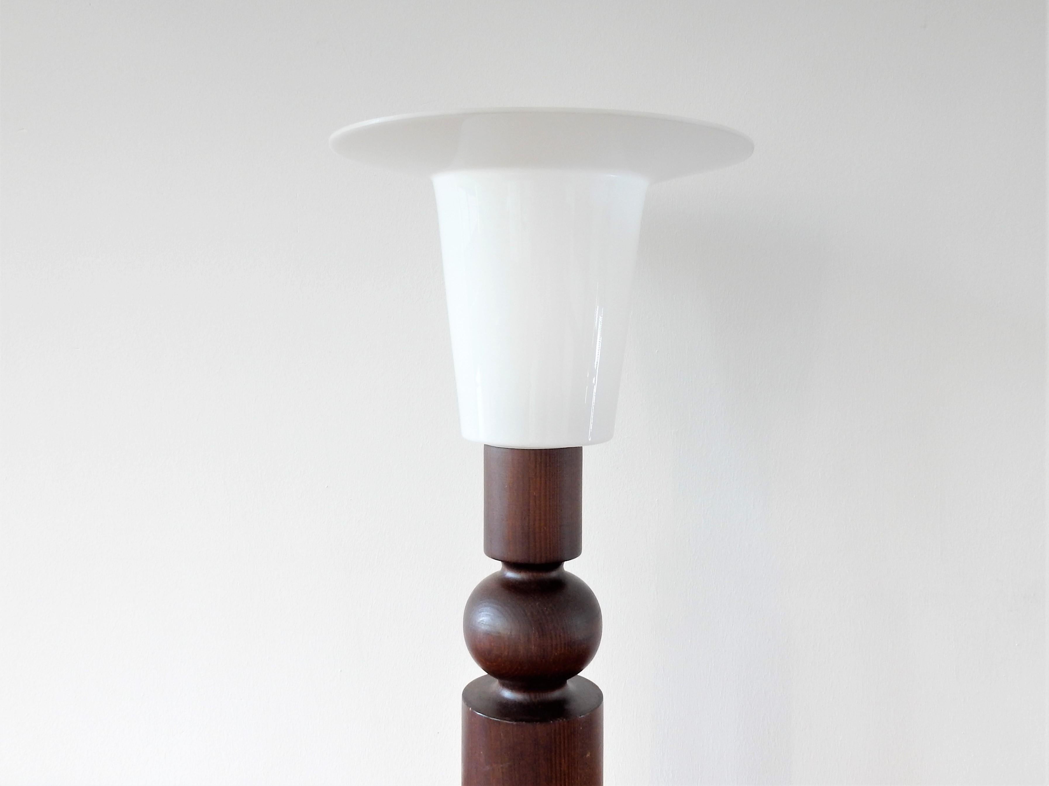 Esta lámpara de sobremesa fue diseñada por Uno & Östen Kristiansson para Luxus, en Suecia, en la década de 1960. Creemos que esta lámpara en concreto se fabricó a finales de los años setenta o principios de los ochenta. Tiene una base de madera de