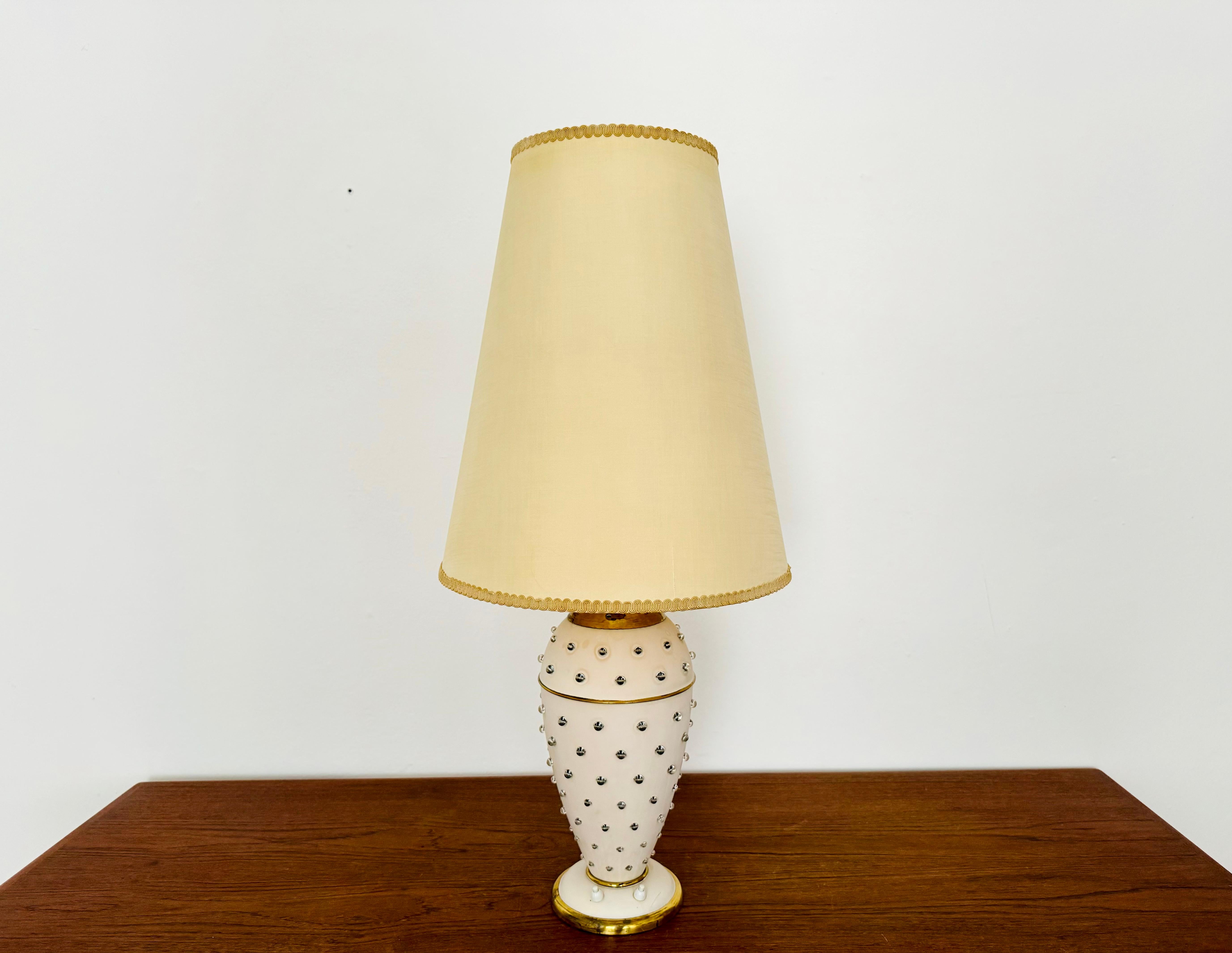 Impressively beautiful table lamp from the 1950s.
Extraordinarily successful design and very high-quality workmanship.
The glass balls in the lamp base create a sparkling light.
A very elegant lamp and an enrichment for every home.

Manufacturer:
