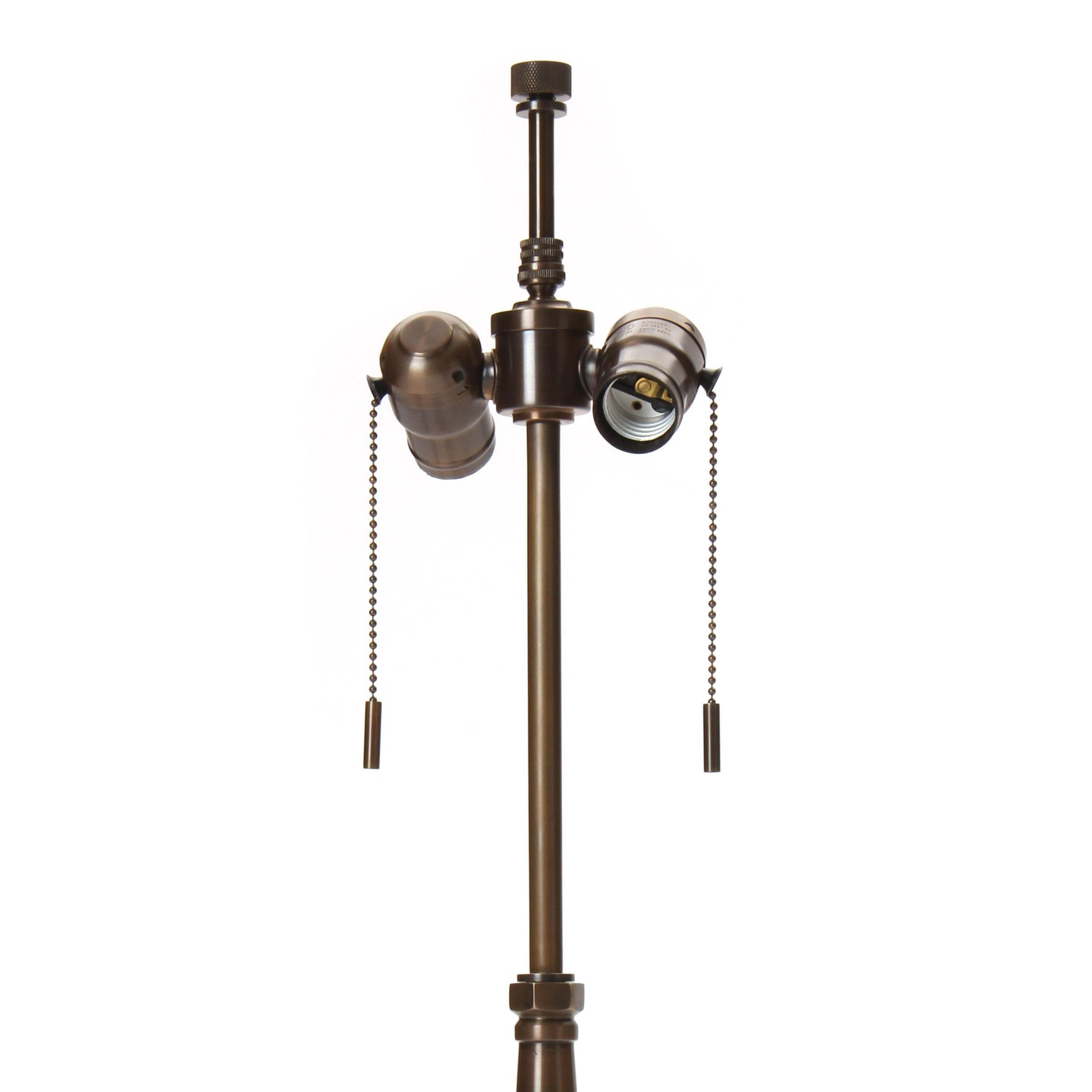 A brass table lamp with a half-dome base and a hand-turned stem. Base is 12