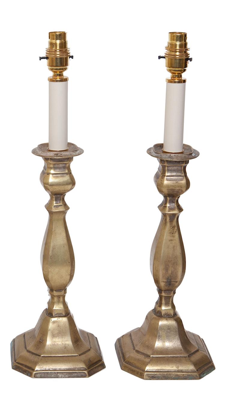 A pair of 19th century, brass candlesticks, upcycled into table lamps, measures: 46cm, 18” high

Practical and suitable for everyday use.
The brass has developed a mellow, patina which can be polished if required.
Blends and sits comfortably in