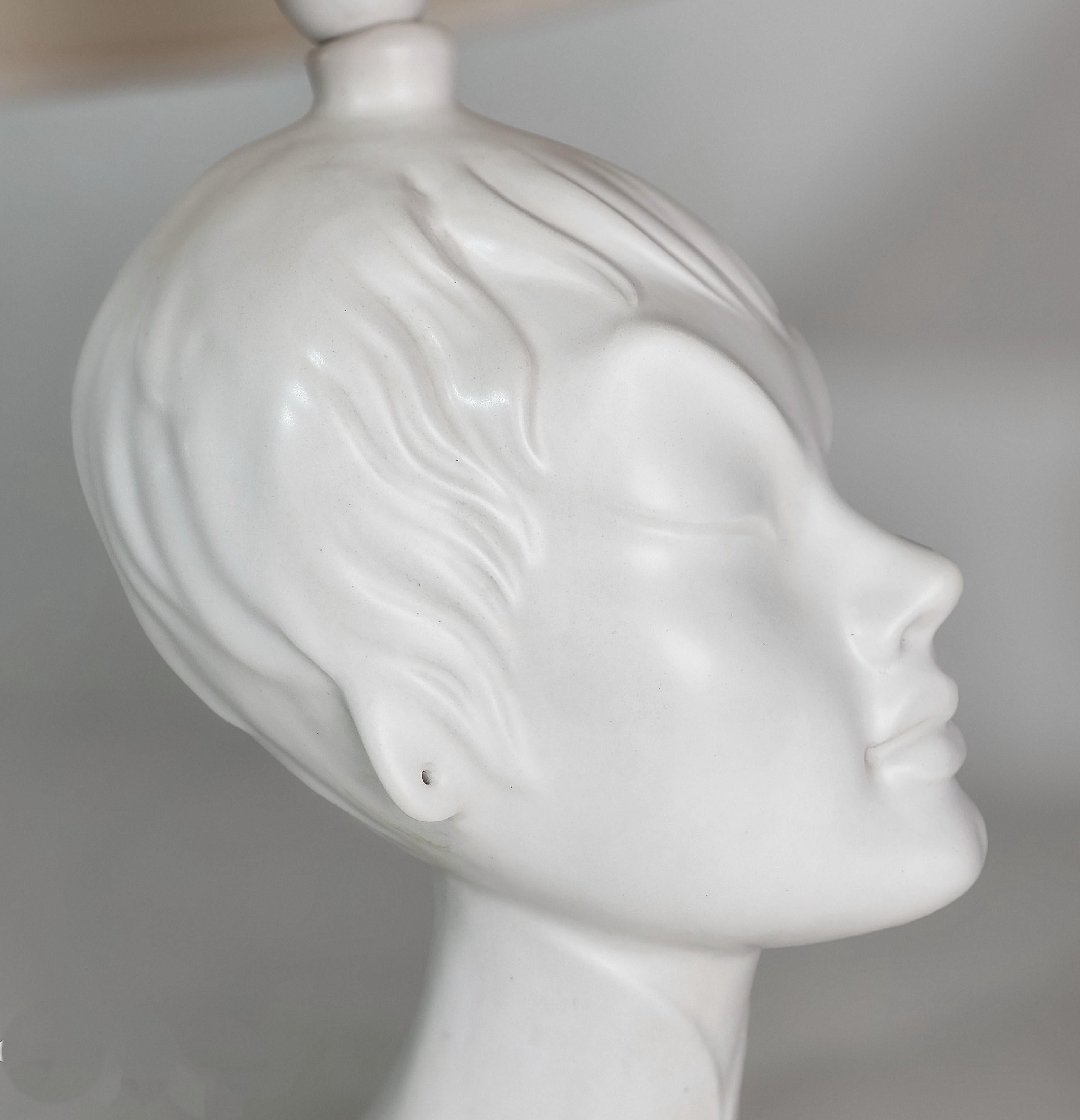 1960s table lamp with Sicas Sesto Fiorentino signature underneath. The lamp was made with a woman's face with Asian features in white matt ceramic with a conical lampshade in shiny plastic material in shades of beige.


Note: We try to offer our