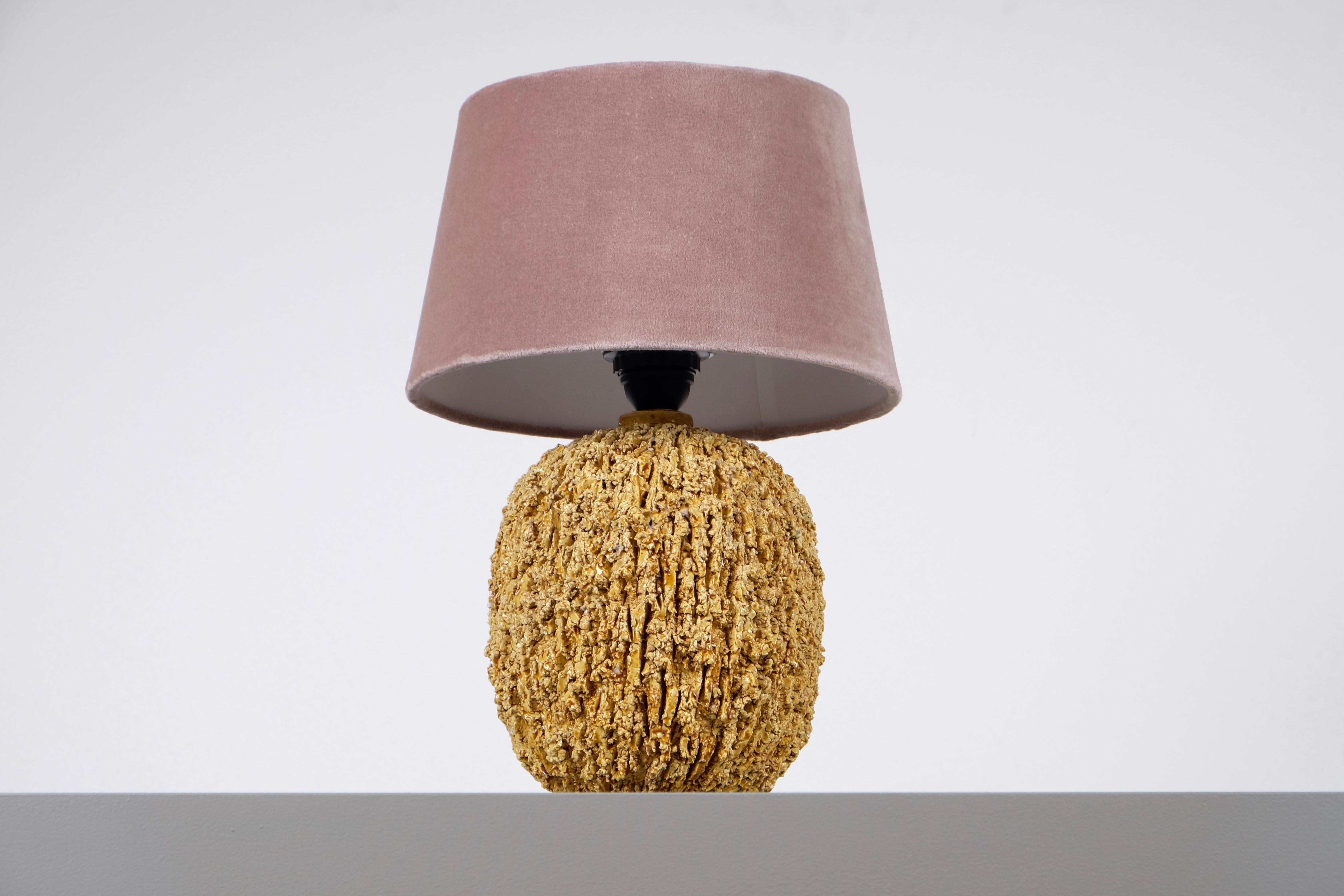 Ceramic lamp in bulbous shape by Gunnar Nylund, composed of chamotte clay and glazed with a gold colored luster glaze. Produced by Rörstrand.
Stamped. Measures: Height including shade 37 cm. New wiring.