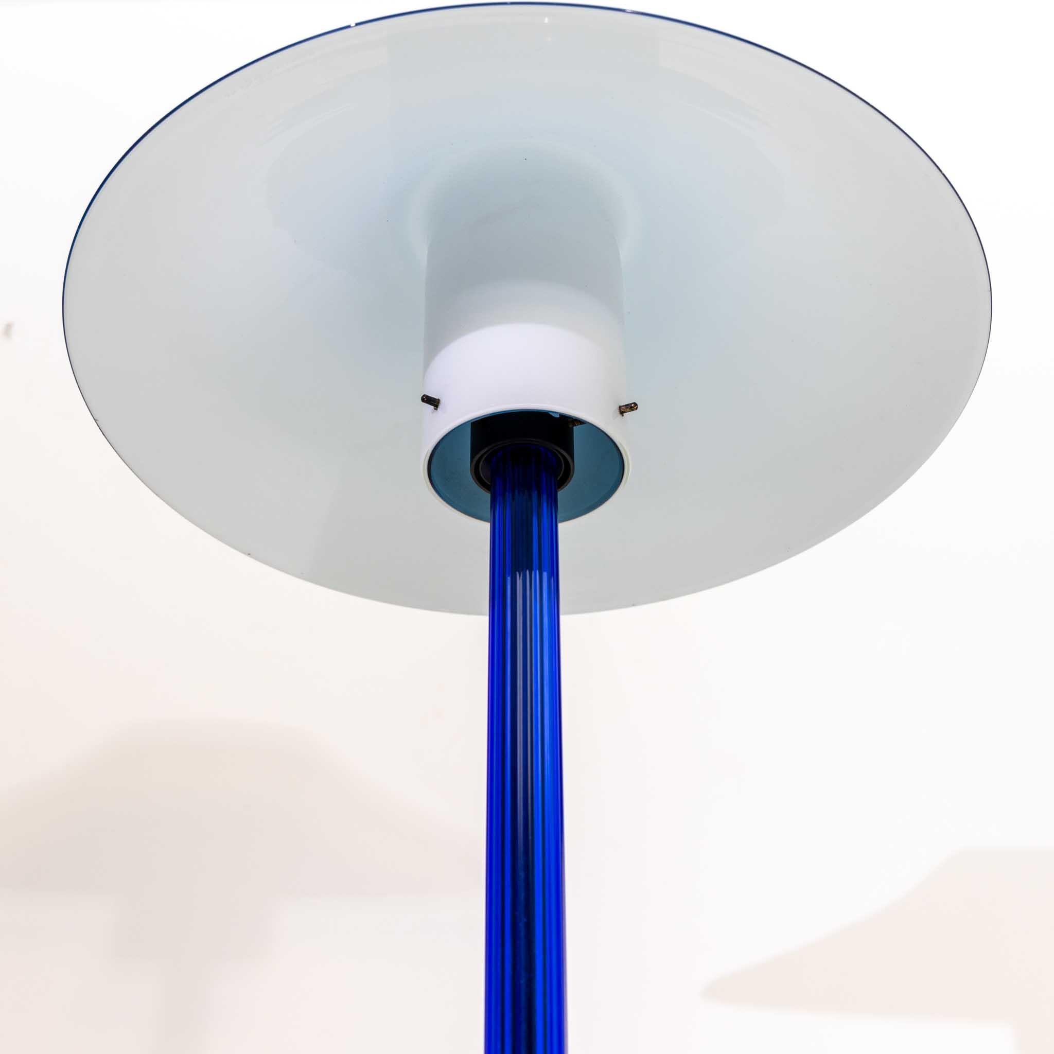 Table lamp Chiara in the blue version with round base, dark blue stem and light blue glass shade with white interior. Giuliana Gramigna: Design Italiano - Repertorio dell'arredo domestico, 1950-2000. Torino 2021, p. 334.