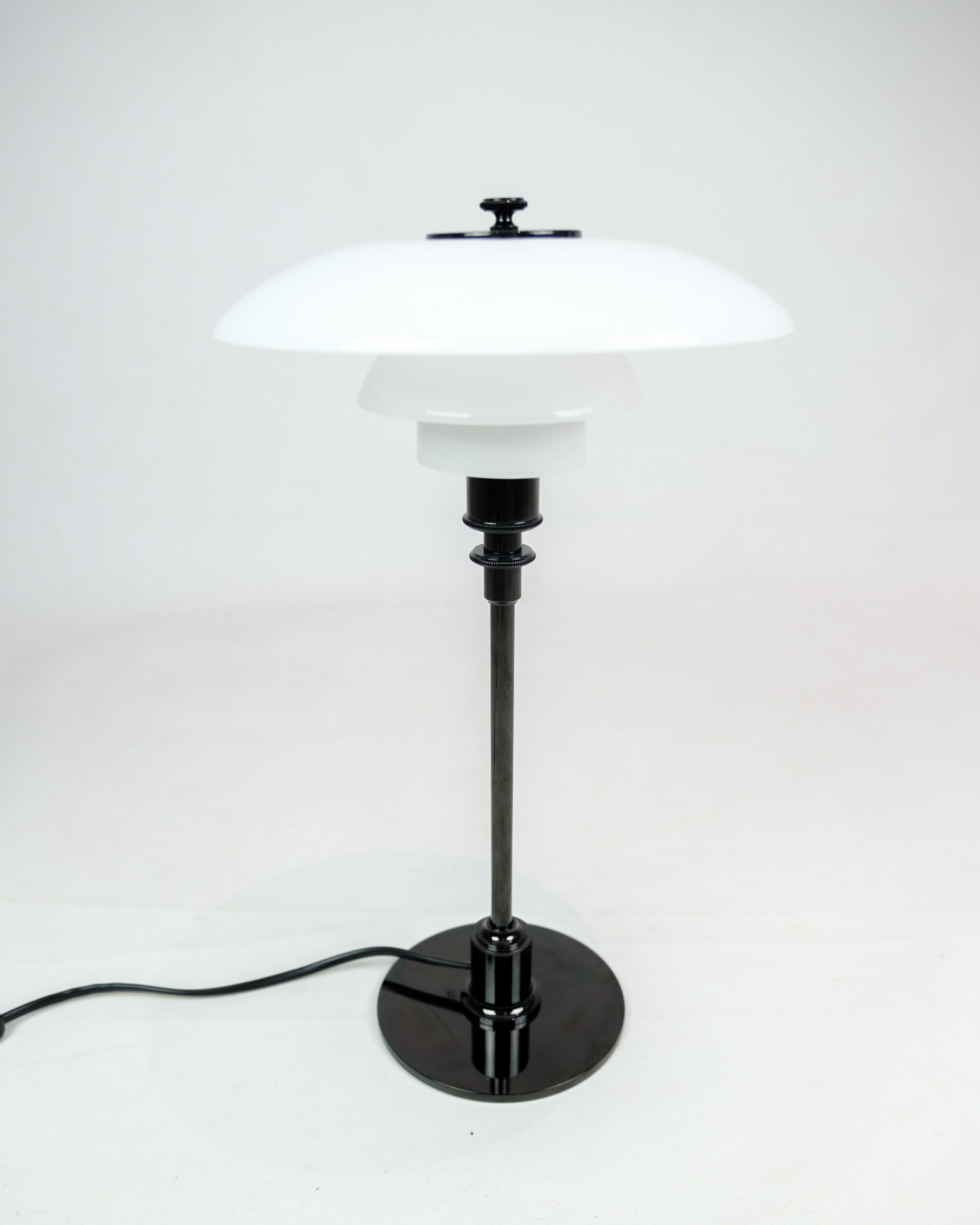 Experience the timeless elegance of Poul Henningsen's iconic design with this table lamp, model 3/2, in black metallized design, manufactured by Louis Poulsen. This lamp is not just a light source; it is a masterpiece of mid-century lighting design