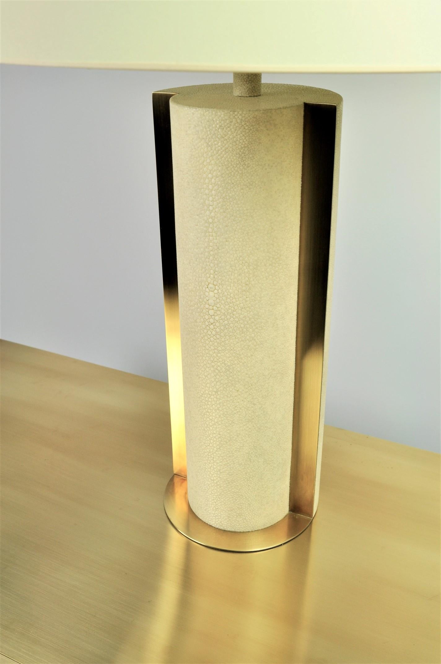 The table lamp ECLIPSE by Ginger Brown is made of shagreen and brushed brass trims.
The style is timeless with a modern touch thanks to its cylindrical shape. A must have on a large console table or a dresser.

This lamp can be delivered with EU,