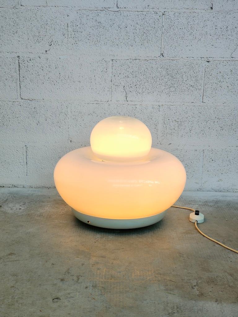 Cette lampe de table a été conçue par Giuliana Gramigna per Artemide - Italie - et a été produite par Artemide en Italie en 1968. Il comporte une grande base ronde en verre blanc et un sommet arrondi plus petit en verre plus clair. La lampe peut