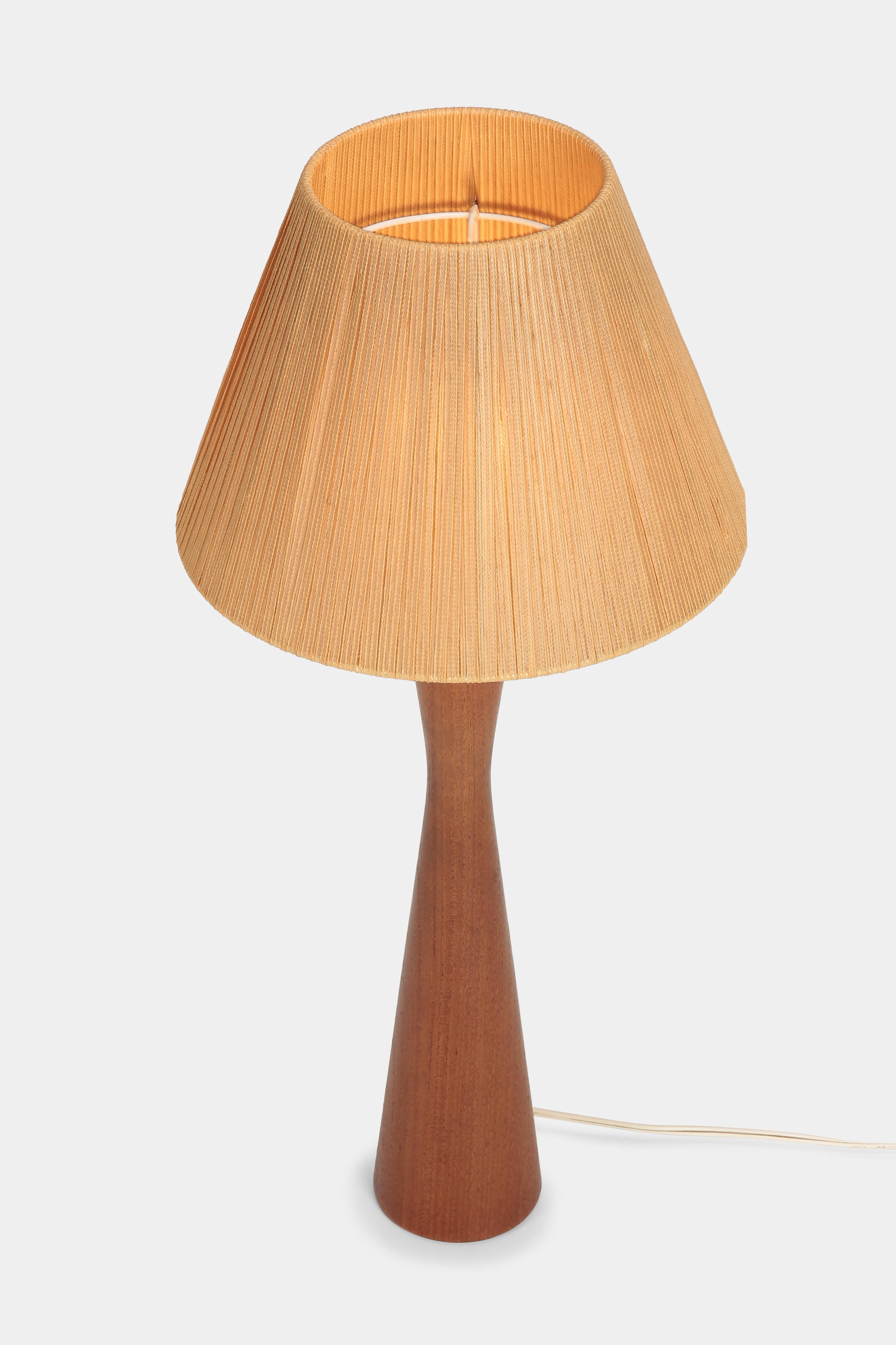Beautiful, tall table lamp made of solid teak wood and with an authentic braided cord lampshade by the company ESA from Denmark. The lamp is in very good vintage condition. The lampshade has a diameter of 29.5cm and is 21cm long.