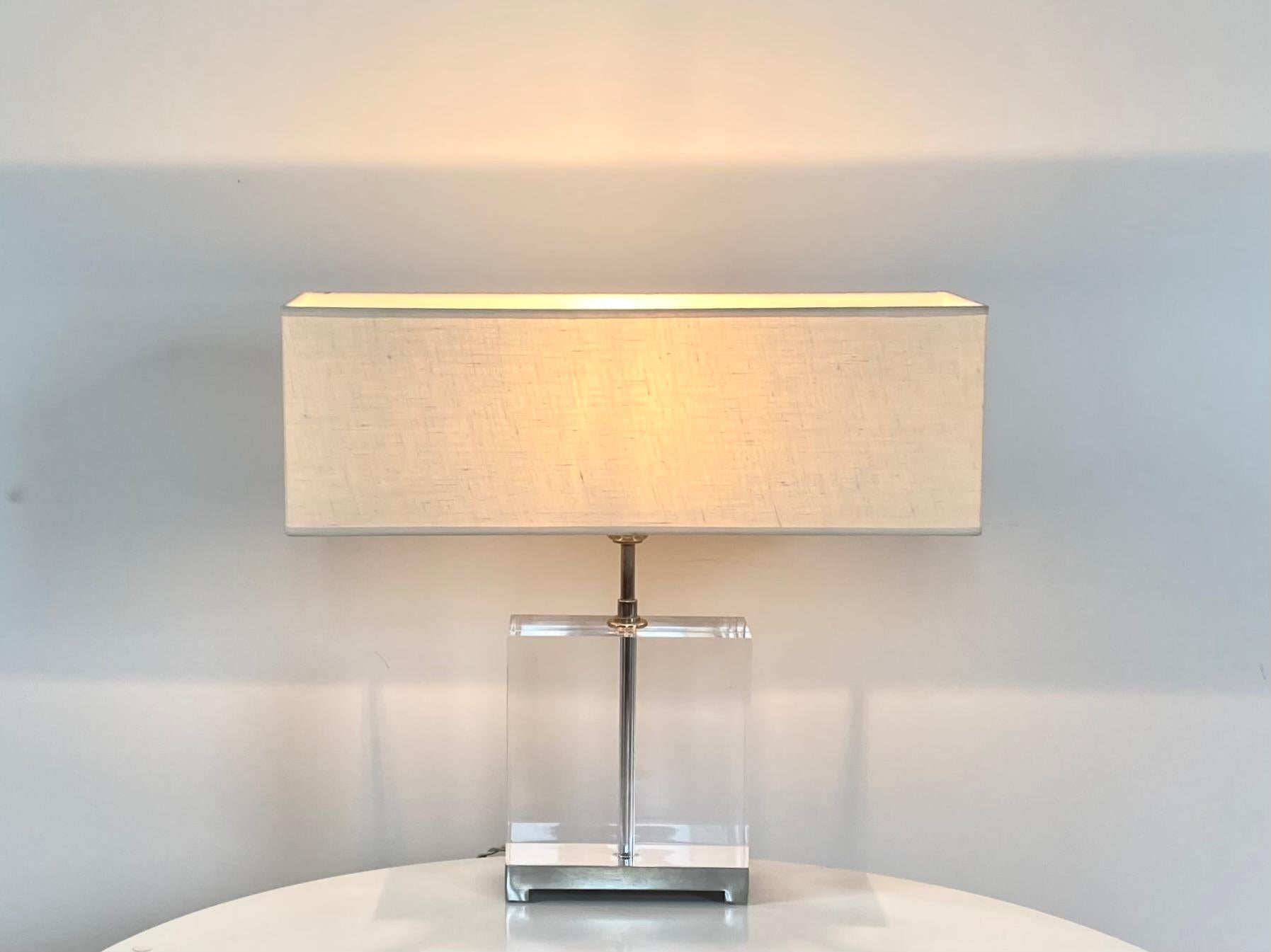 Italian table lamp. The base is a block of Altuglass resting on a metal base. The shade in ivory fabric has just the right proportions; it has an only mark on the right corner of the back. The structure and base are in excellent condition, no