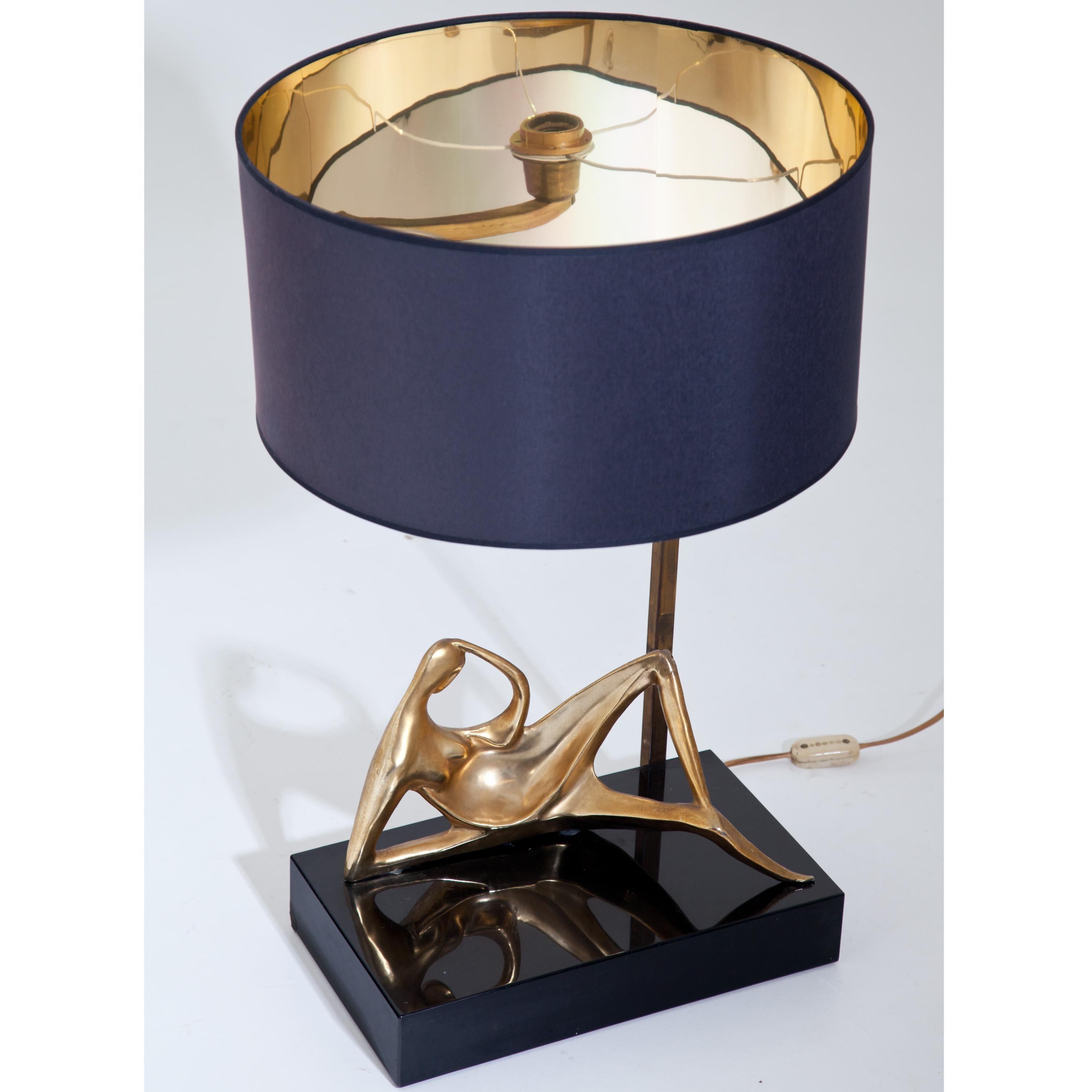 Italian table lamp with round fabric shade standing on a black rectangular base with a reclining female bronze nude. There signed 