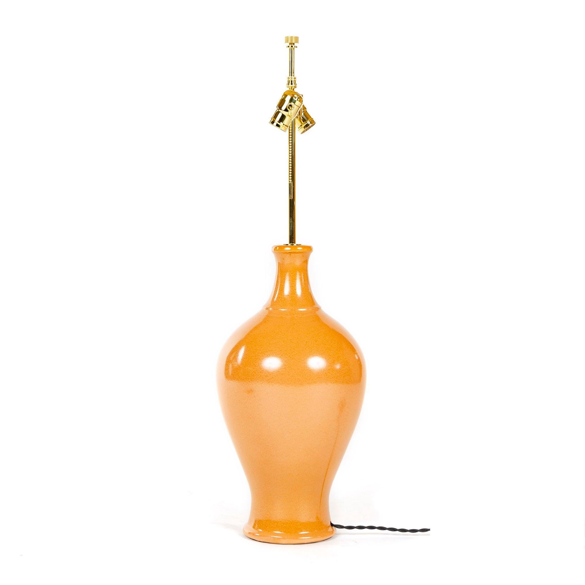 A classic, bulbous vase form rendered as a large curvaceous high glaze ceramic table lamp. Includes solid brass custom light fitting consisting of a circular cover plate for the rod hole, vertical rod, double socket ball cluster each socket with a