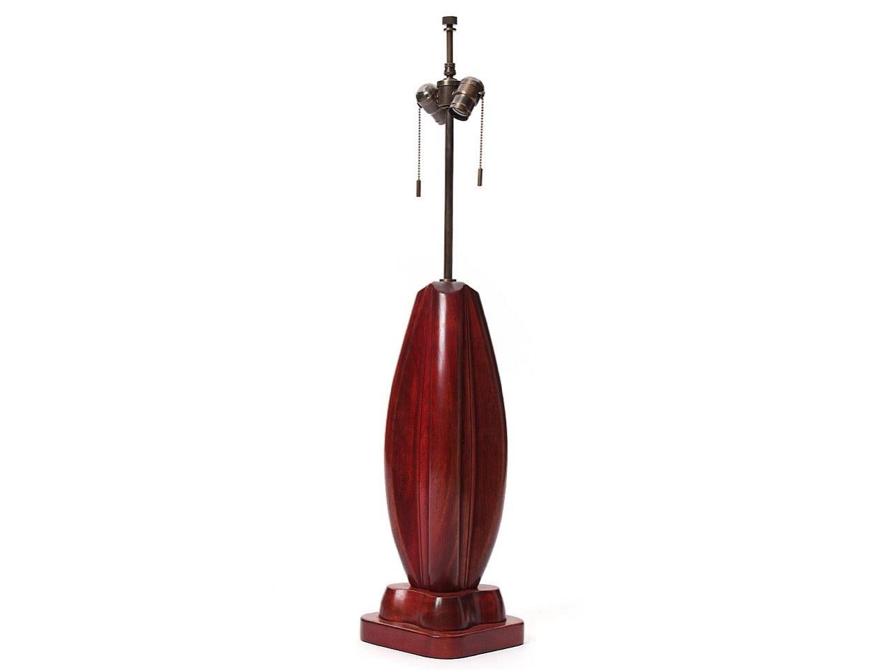 Una lampada in legno intagliato con macchie rosse.