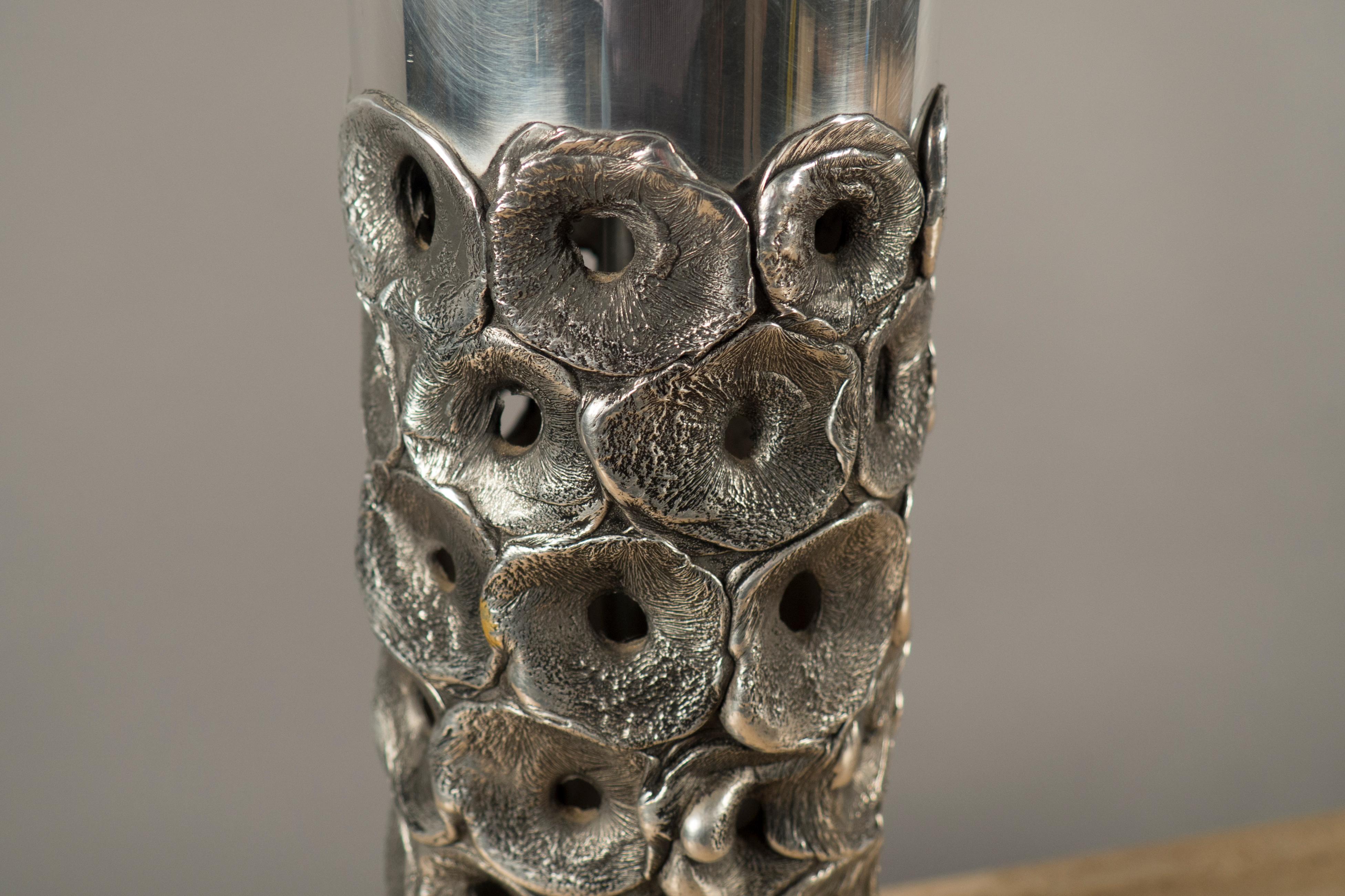 Cylindrical aluminum body decorated with circular discs containing a hole in their center.
 
(Lamp shade not included)