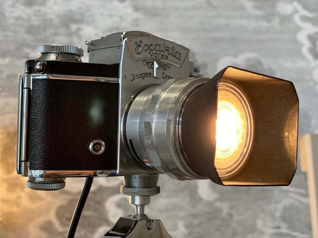 Table lamp made from an Exakta Varex camera. This lamp is an upcycling project from someone with a knack for special things. Because the small lamp consists of an old 1950s Exakta Varex camera and a tripod. Since the former lens of the camera has