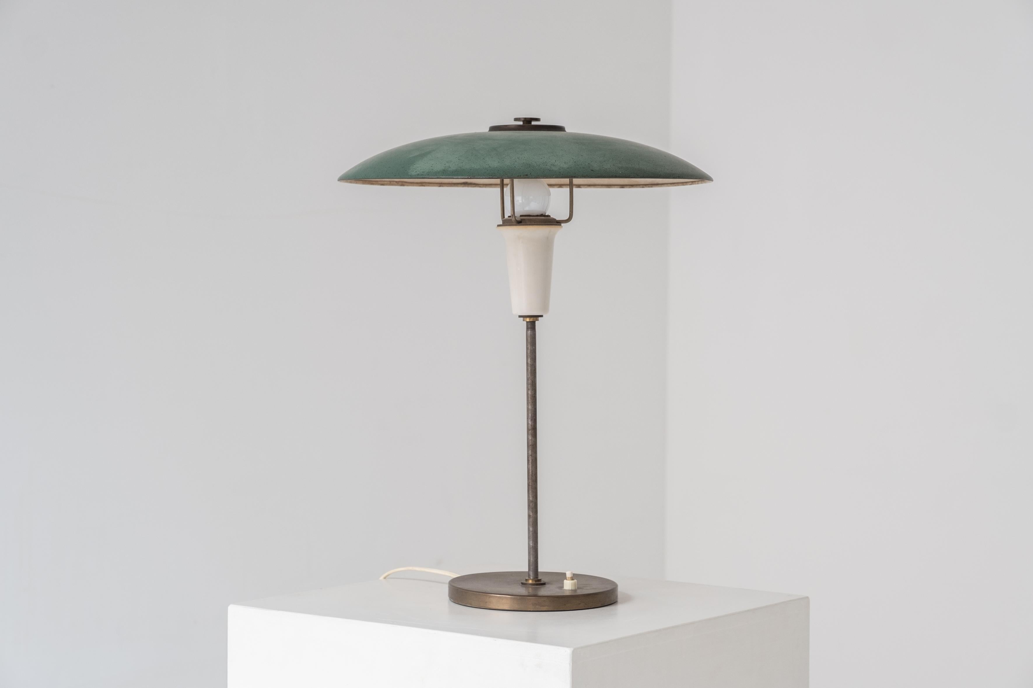 Charmante lampe de table du Danemark, conçue et fabriquée dans les années 1960. Cette lampe de table est en métal et présente une belle patine d'ensemble, en particulier sur l'abat-jour vert. Modernité danoise classique.