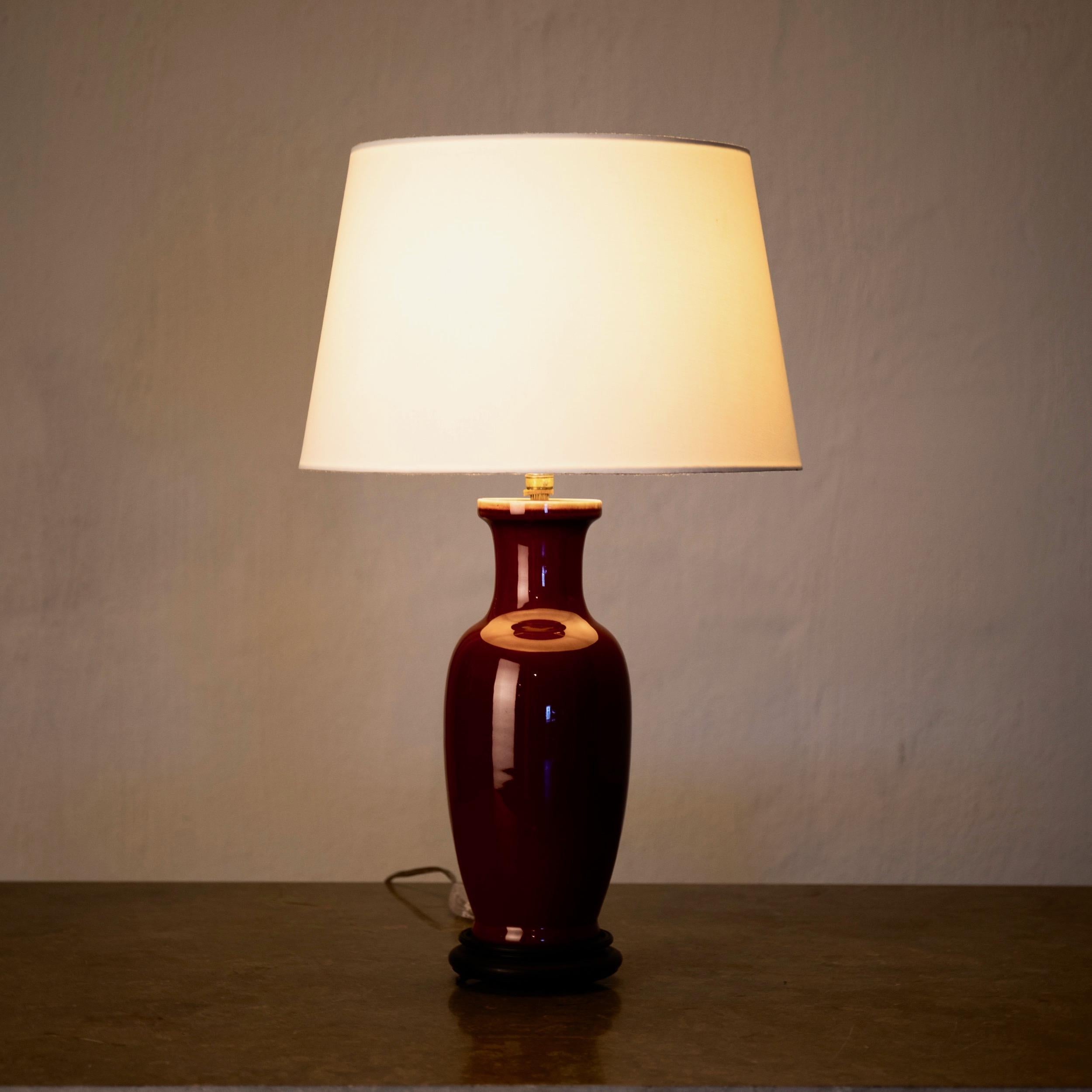 Table lamp glazed red 19th century, China. A table lamp made in a deep red glazed pottery.
Measures: H with shade: 22.5”, H without shade: 16”, diameter of foot: 5”.
 