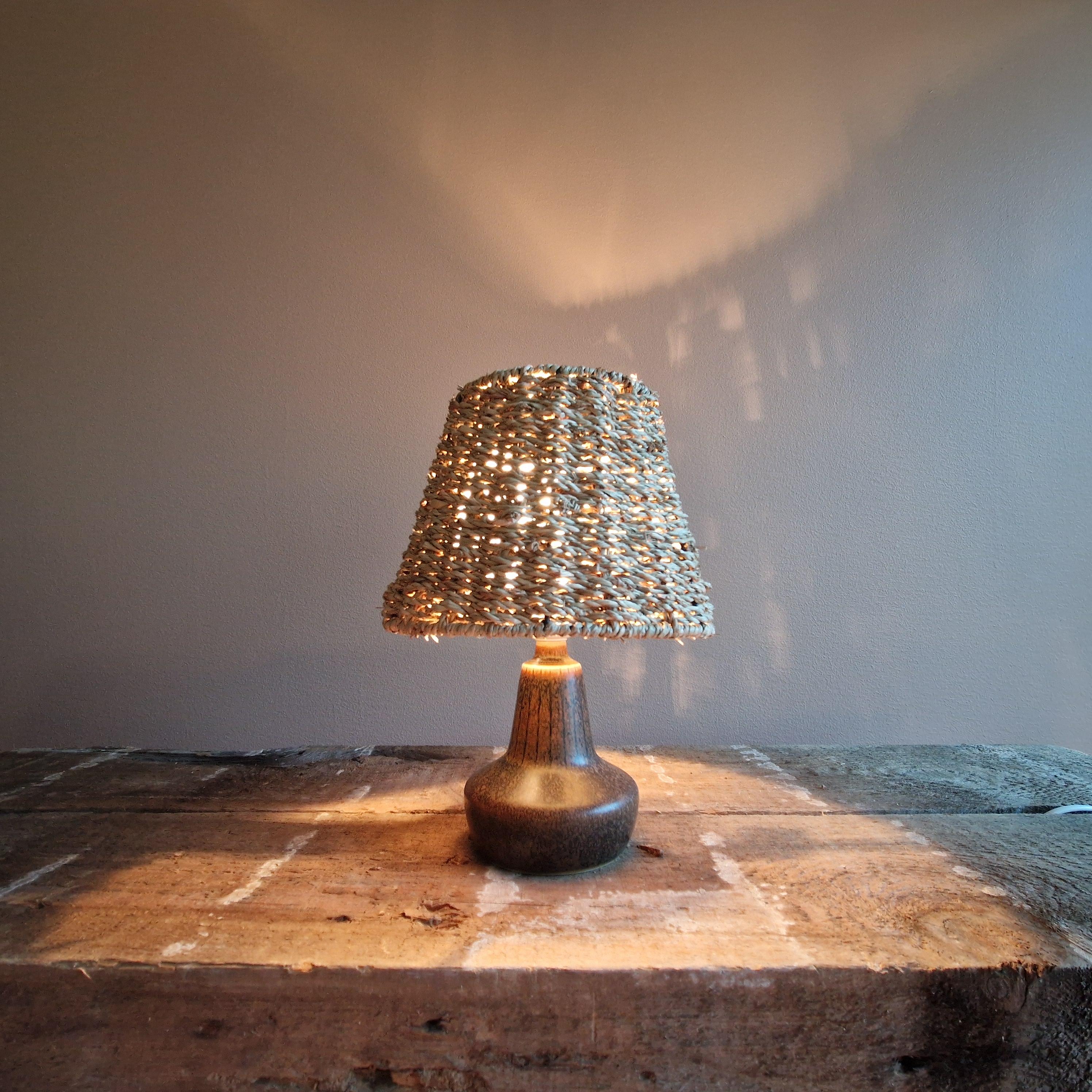 Una grande lampada da tavolo disegnata da Gunnar Nylund. Di dimensioni ridotte, è un ottimo esempio del suo stile negli anni '40 e '50. Firmato e contrassegnato da Rörstrand. Smaltata in marrone, crea una luce pastosa e accogliente con il suo nuovo