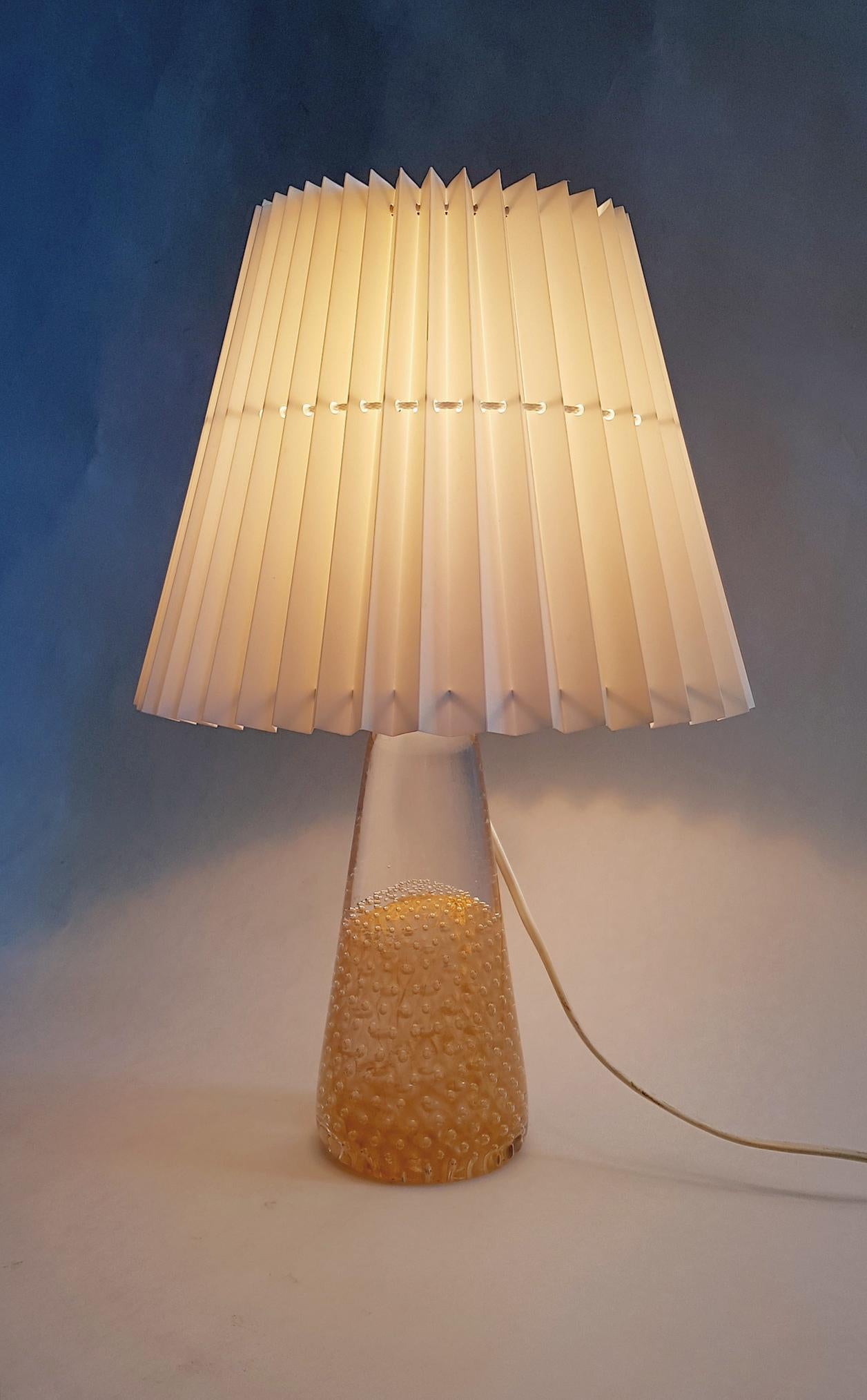 A beautiful and exquisite handmade table lamp in art glass encased with 24-karat gold by Glass House Marcolin Art Crystal, Sweden and a white classic pleated white lampshade.

Färe-Marcolin Art Glass (from 1983 FM Marcolin Art Crystal, and from