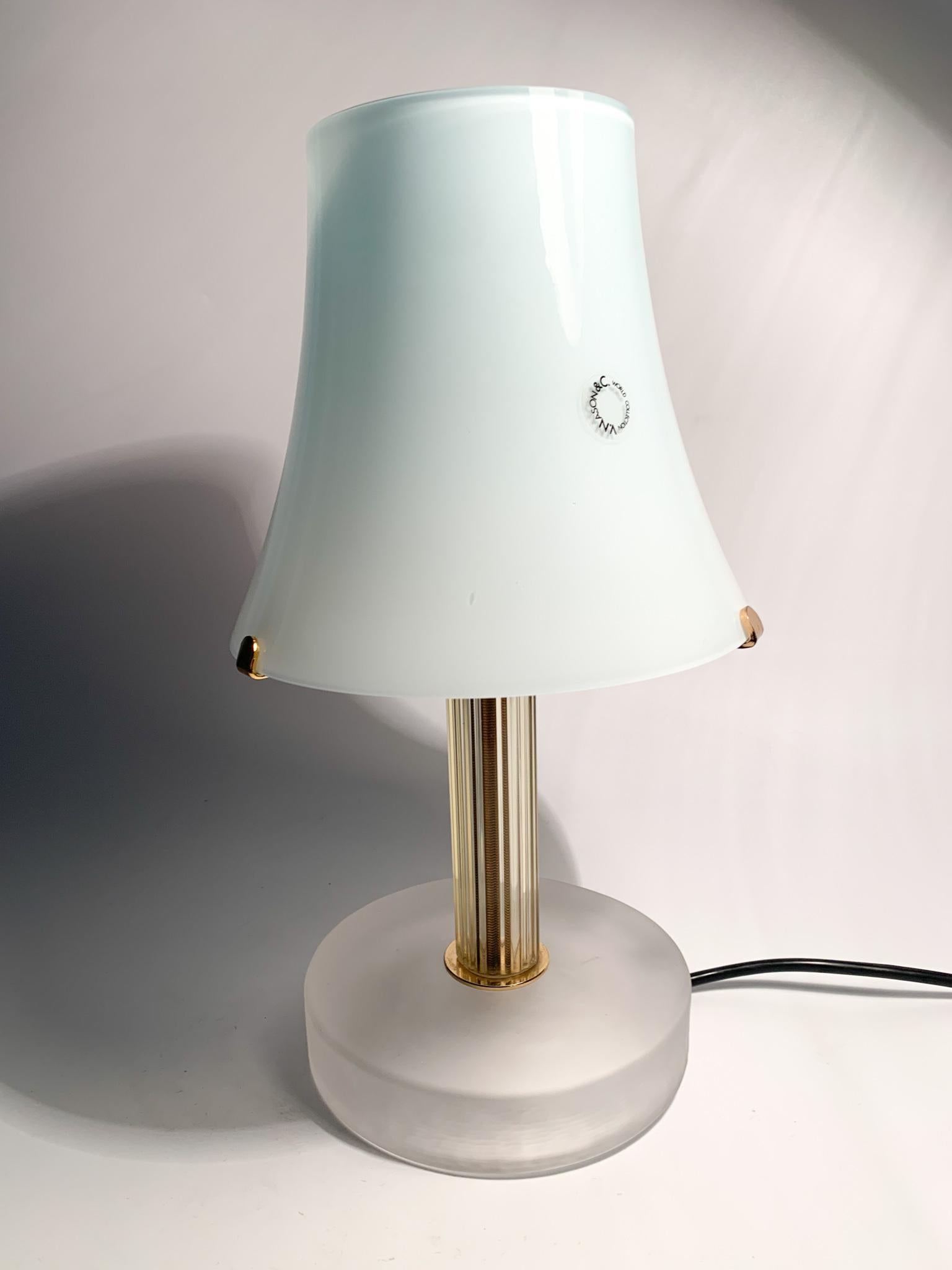 Murano glass table lamp by Nason, made in the 1980s. The lamp is composed of a pastel blue glass hat, a golden glass stem and an opaque white glass base. 

Ø cm 17 h cm 31

Carlo Nason, born in Murano in 1935 from one of the oldest families of