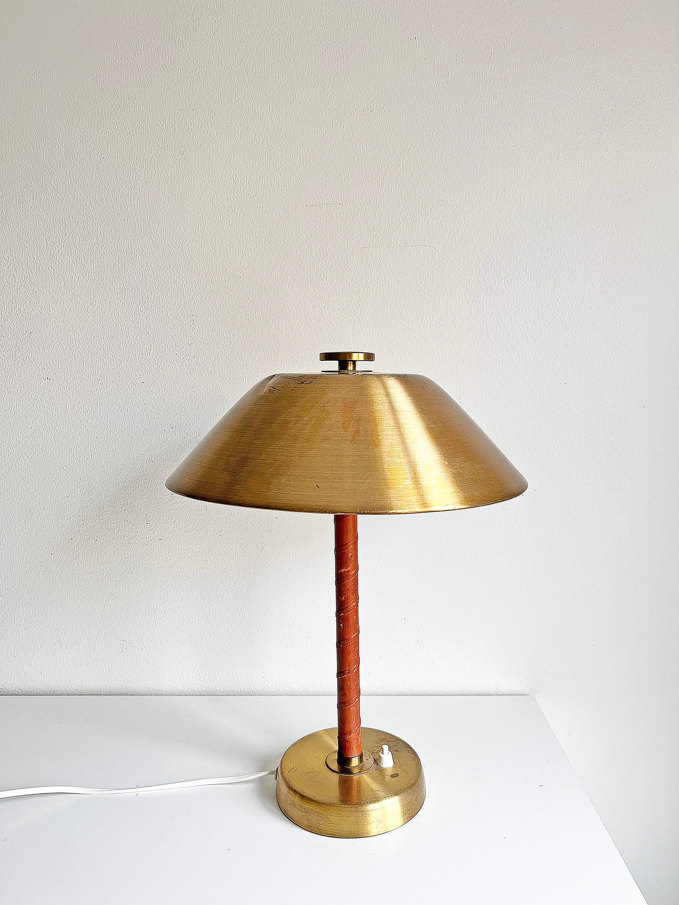 Table lamp model 5014 in brass and cognac leather by Einar Bäckström circa 1940s.
Signed on the bottom. Rewired. We recommend this lamp to be rewired following the buyer's country's electrical standards.

Condition: Please Notice! there is a dent