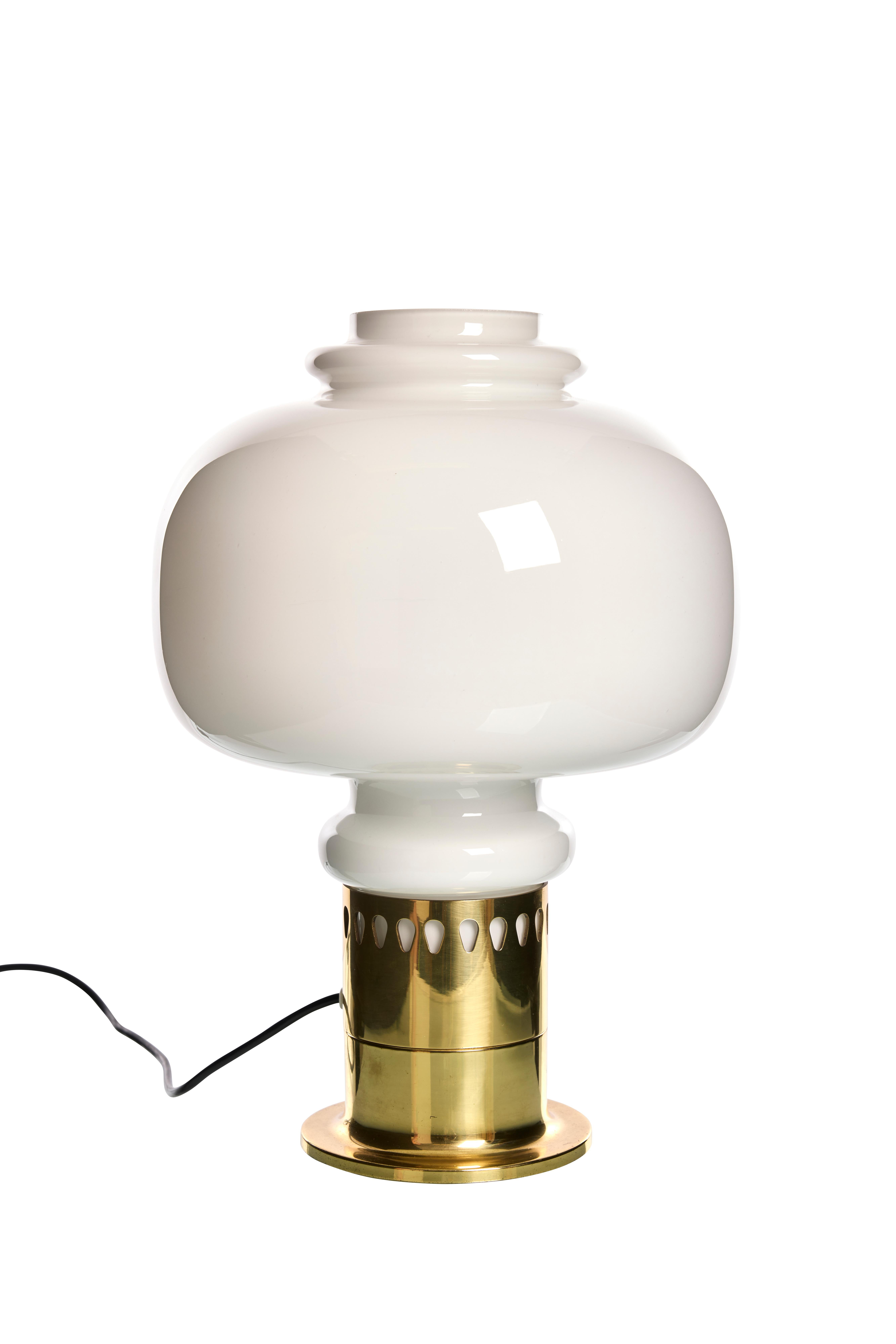 Questa squisita lampada da tavolo, progettata dal famoso designer svedese Hans-Agne Jakobsson negli anni '60, incarna il perfetto connubio tra forma e funzione. Caratterizzata da un'elegante base in ottone che aggiunge una sofisticata lucentezza,