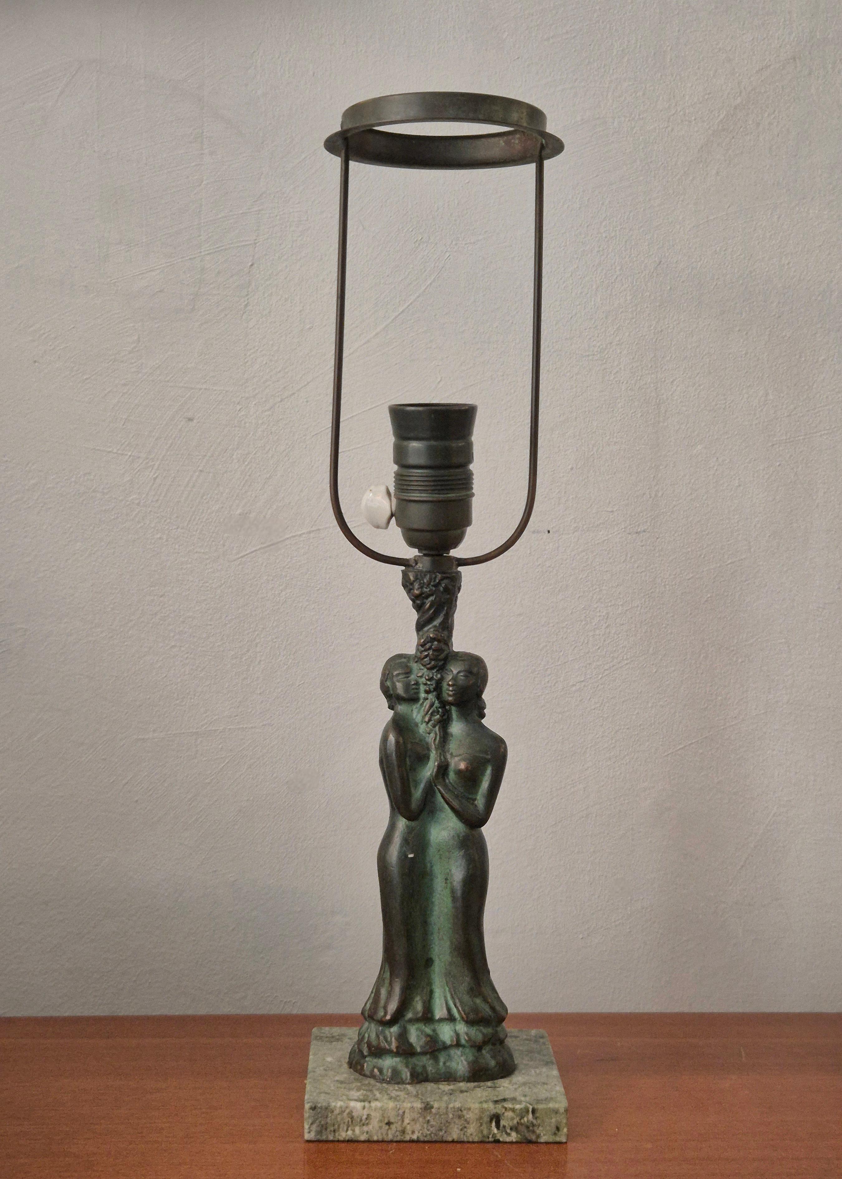 Lampe de table Grace scandinave en bronze avec base en marbre vert, décor de deux figures féminines embrassant un arbre. 

L'abat-jour n'est pas inclus, hauteur avec le support d'abat-jour 47 cm. 

En bon état, petits signes d'âge et d'utilisation.