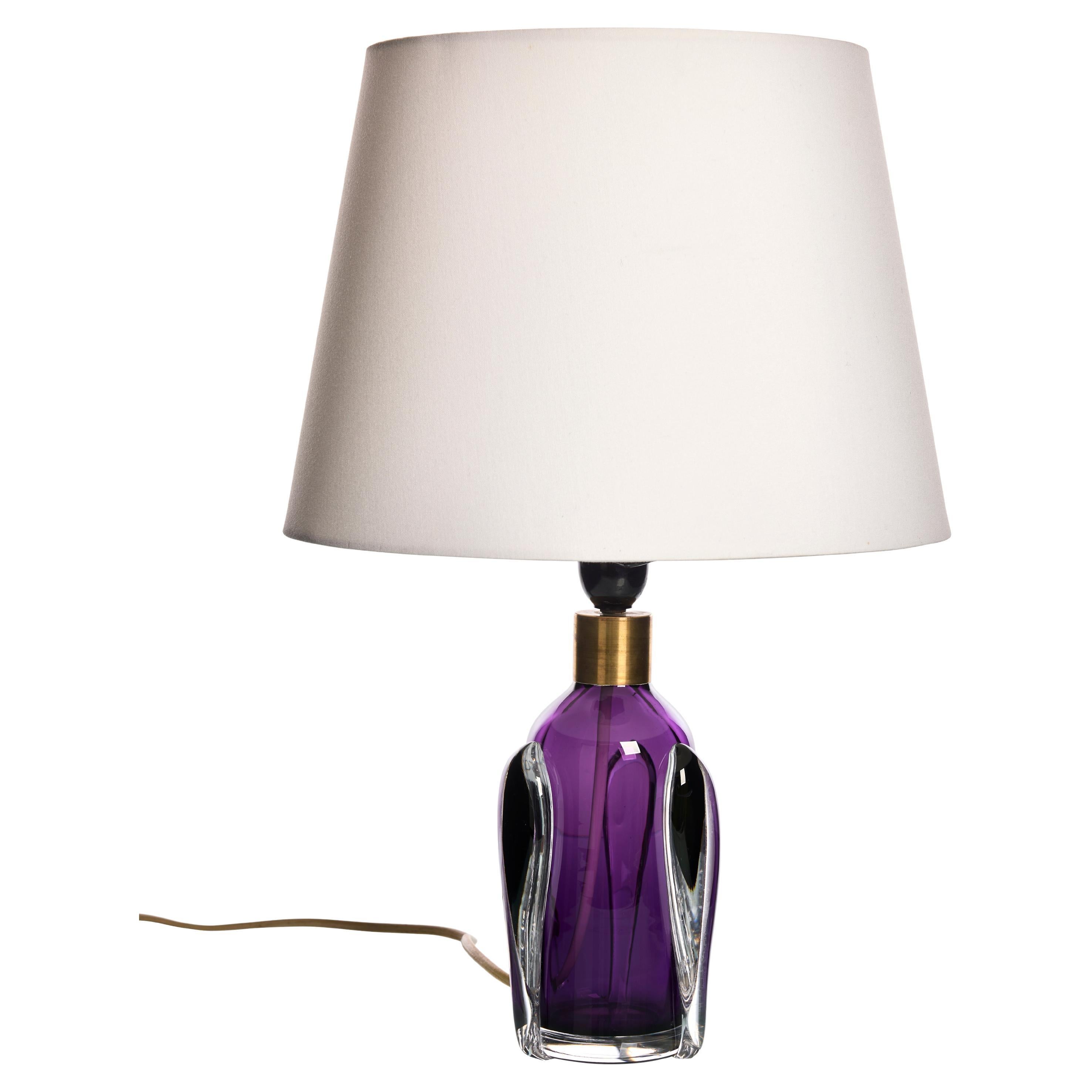 Lampe de table vintage Orrefors, années 1960

Cette élégante lampe de table d'Orrefors, fabriquée dans les années 1960, présente une combinaison frappante de verre violet et transparent. La base présente un cœur en verre violet vibrant entouré de