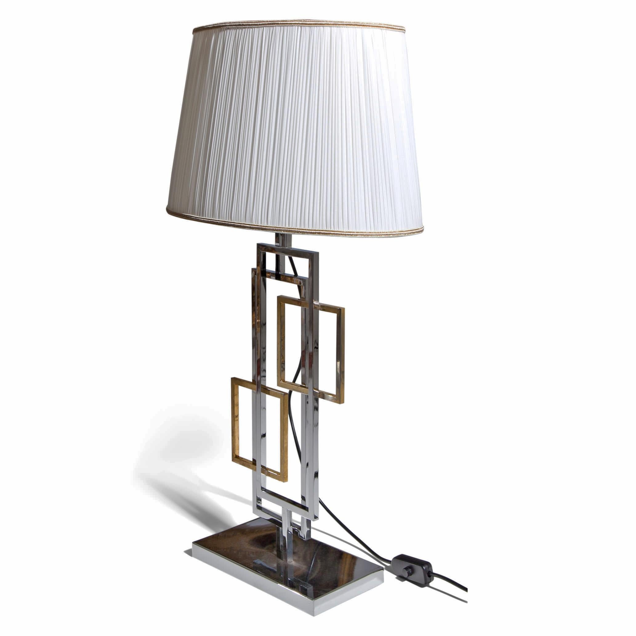 Italian Lamp in the style of Romeo Rega standing on a rectangular chrome foot with geometrical forms out of brass and metal and a beige lamp shade (recent). 

For the electrification we assume no liability and no warranty.