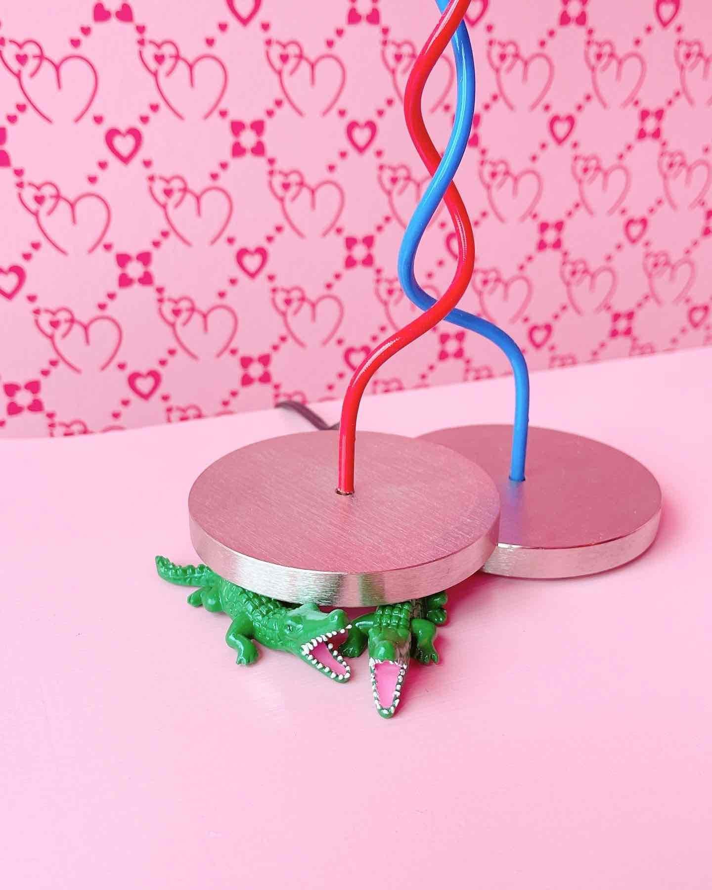 Marque : Ingo Maurer
Modèle : One From The Heart
Designer : Ingo Maurer

One From The Heart a été conçu à l'origine comme un cadeau de mariage pour des amis. Son design ludique présente deux câbles entrelacés, l'un bleu et l'autre rouge, sous un