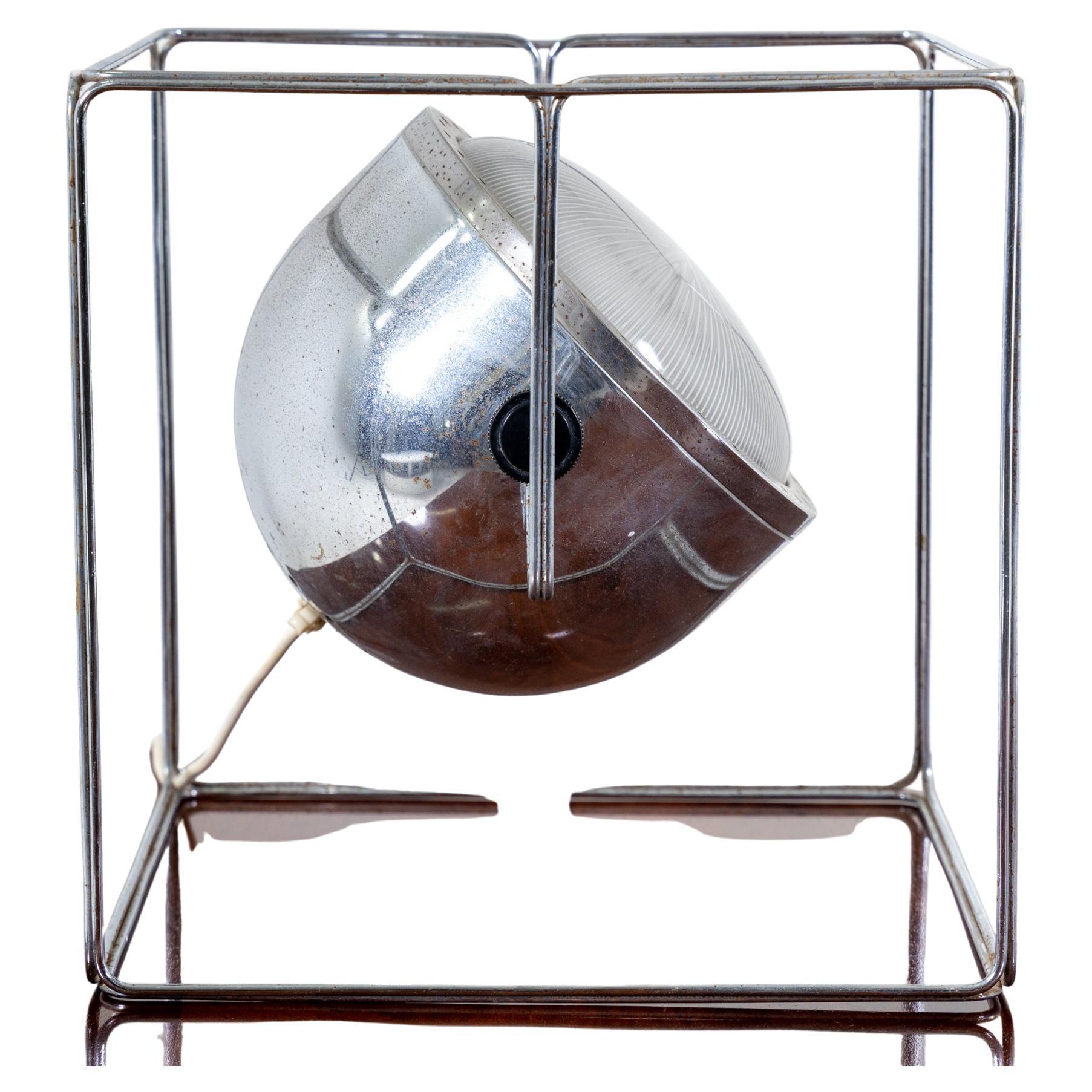 Table lamp with cubic chromed metal frame and spotlight-shaped adjustable lampshade.