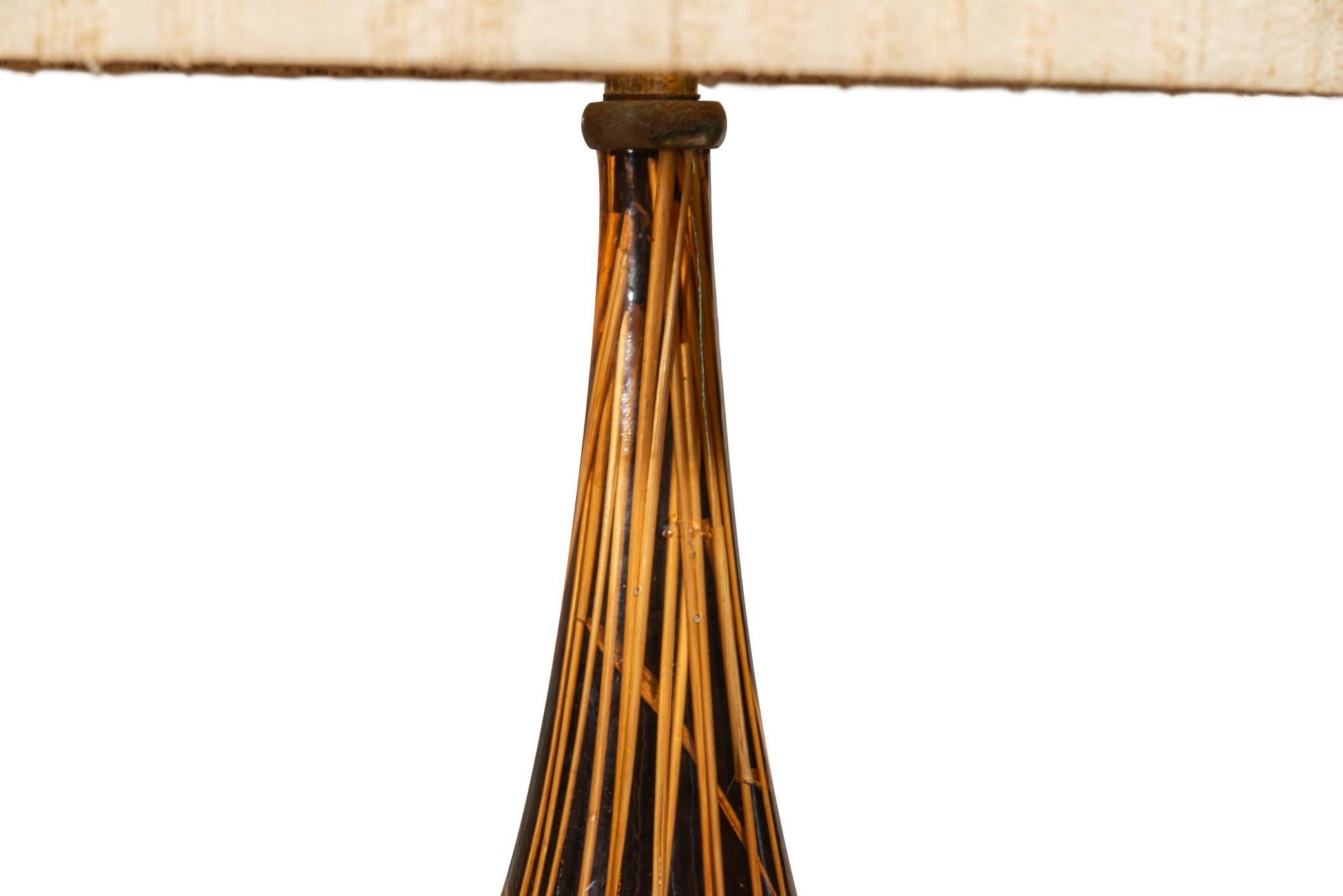 Table lamp,
Decorated with ear of wheat inclusions,
Resin and brass, 
With lampshade, 
Italy, circa 1960.

Measures: Height 84 cm, diameter 40 cm.