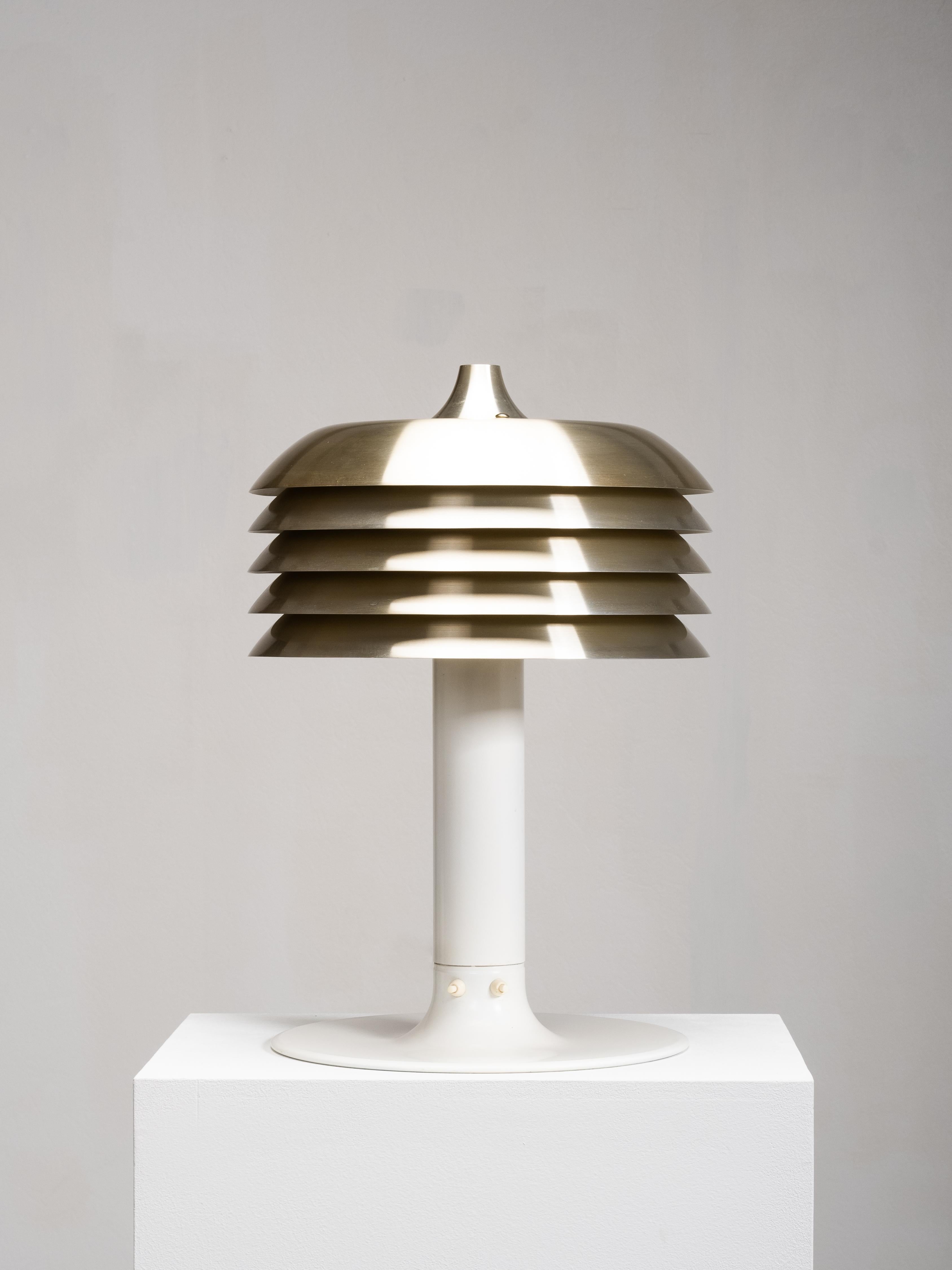 A rare ‘Lamingo’ Model B-186 table lamp by Hans-Agne Jakobsson, produced by his company in Markaryd, Sweden, during the 1960s. The lamp features Jakobsson’s distinctive layered aluminium shade, finished with brass-coloured lacquer, creating a soft,