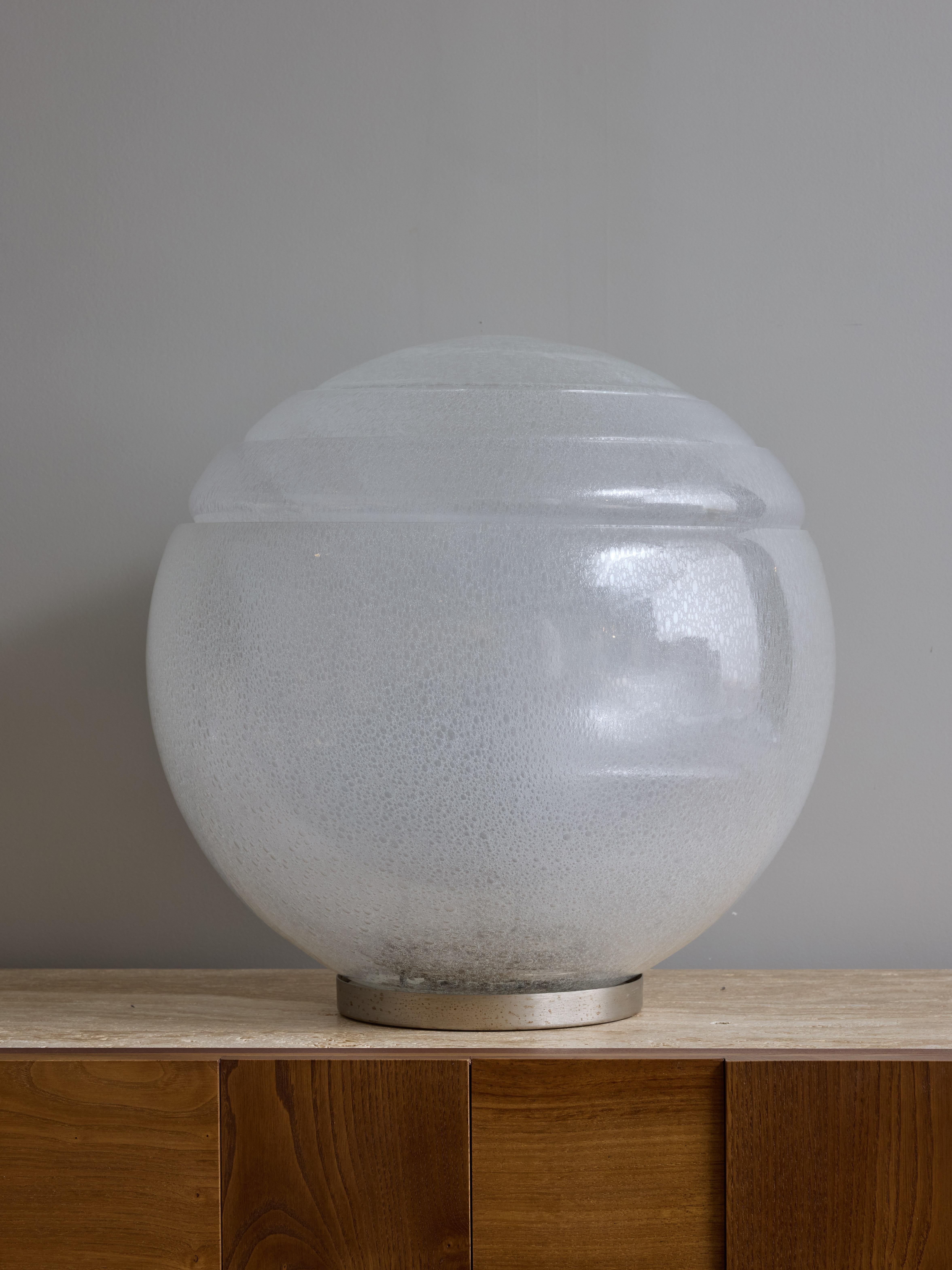 Lampada da tavolo LT328 disegnata da Carlo Nason per Mazzega negli anni '70.

Questa lampada è composta da un piede circolare in metallo e da una pila di quattro parti in vetro che formano un grande globo che diffonde la luce di un'unica sorgente al