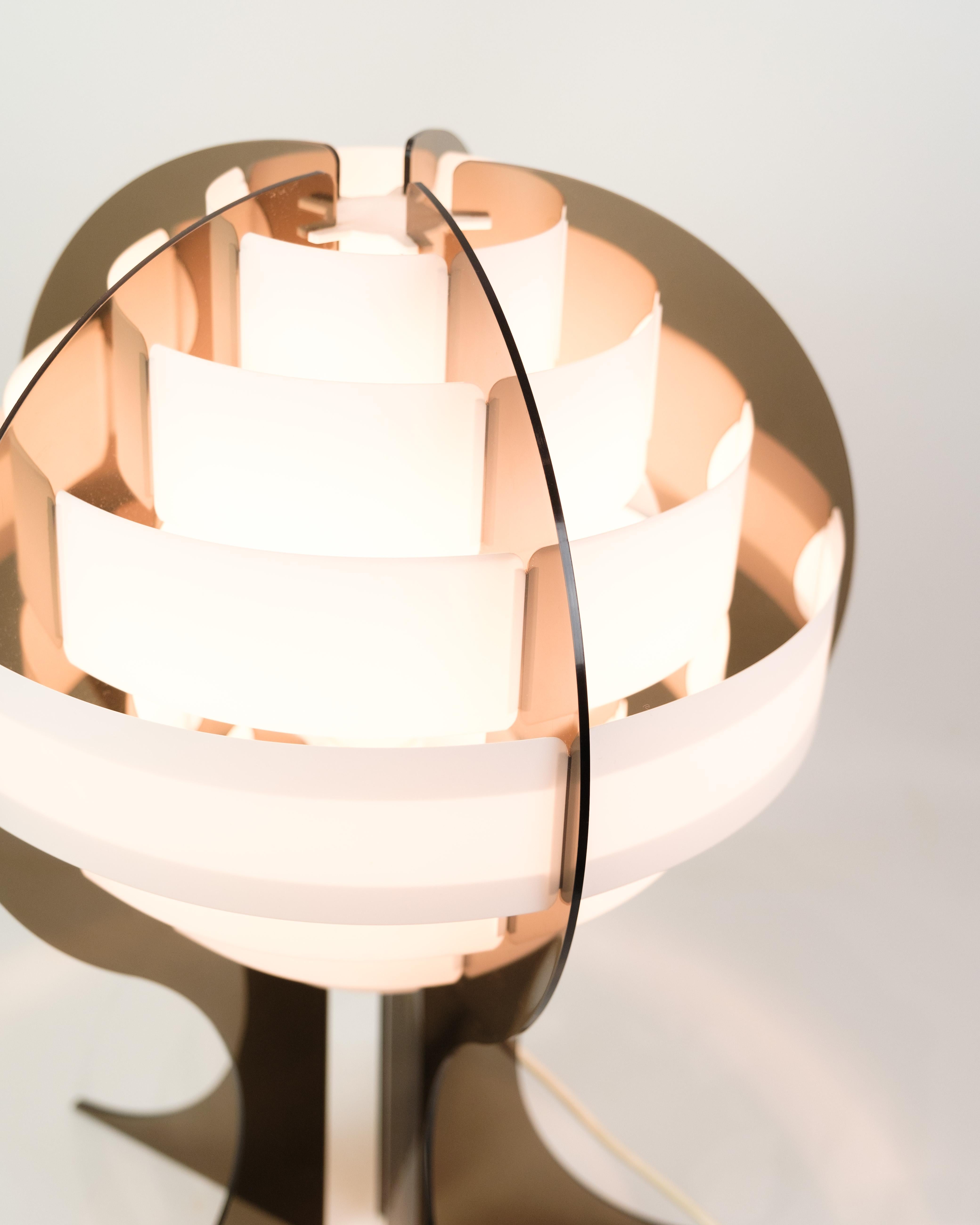 Smoked brown acrylic glass and white acrylic strips make this specially shaped Danish table lamp give off a very special and fantastic light.
Artist Flemming Brylle (born August 26, 1935) and industrial designer Preben Jacobsen designed this lamp in