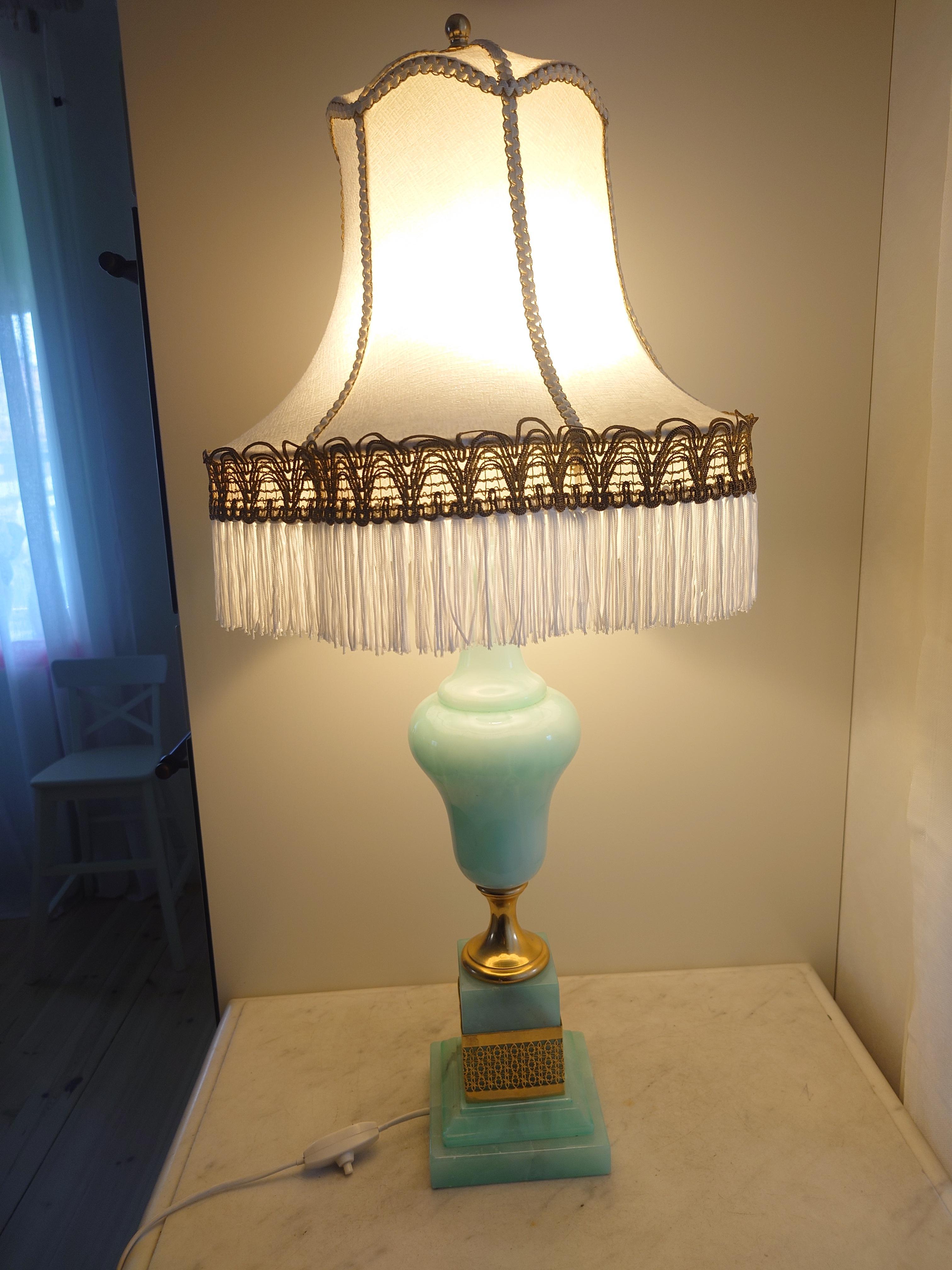 

This decorative table lamp, crafted in Italy during the 1960s or 1970s, epitomizes the era's unique blend of artistic flair and innovative design. Standing at 70cm tall, including its shade, the lamp boasts a refreshing mint green color that adds