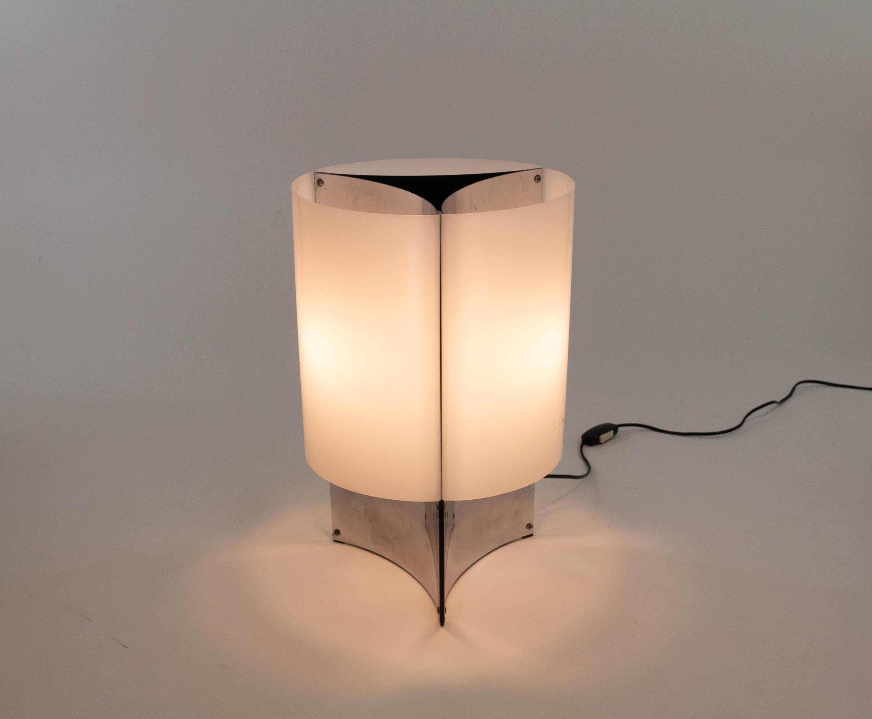 This elegant lamp model 526 was designed in 1965 by Massimo Vignelli for Italian lighting manufacturer Arteluce.

Model 526 is a table lamp with a base that consists of three concave chromed sheets. This base is covered by white Perspex shades. It