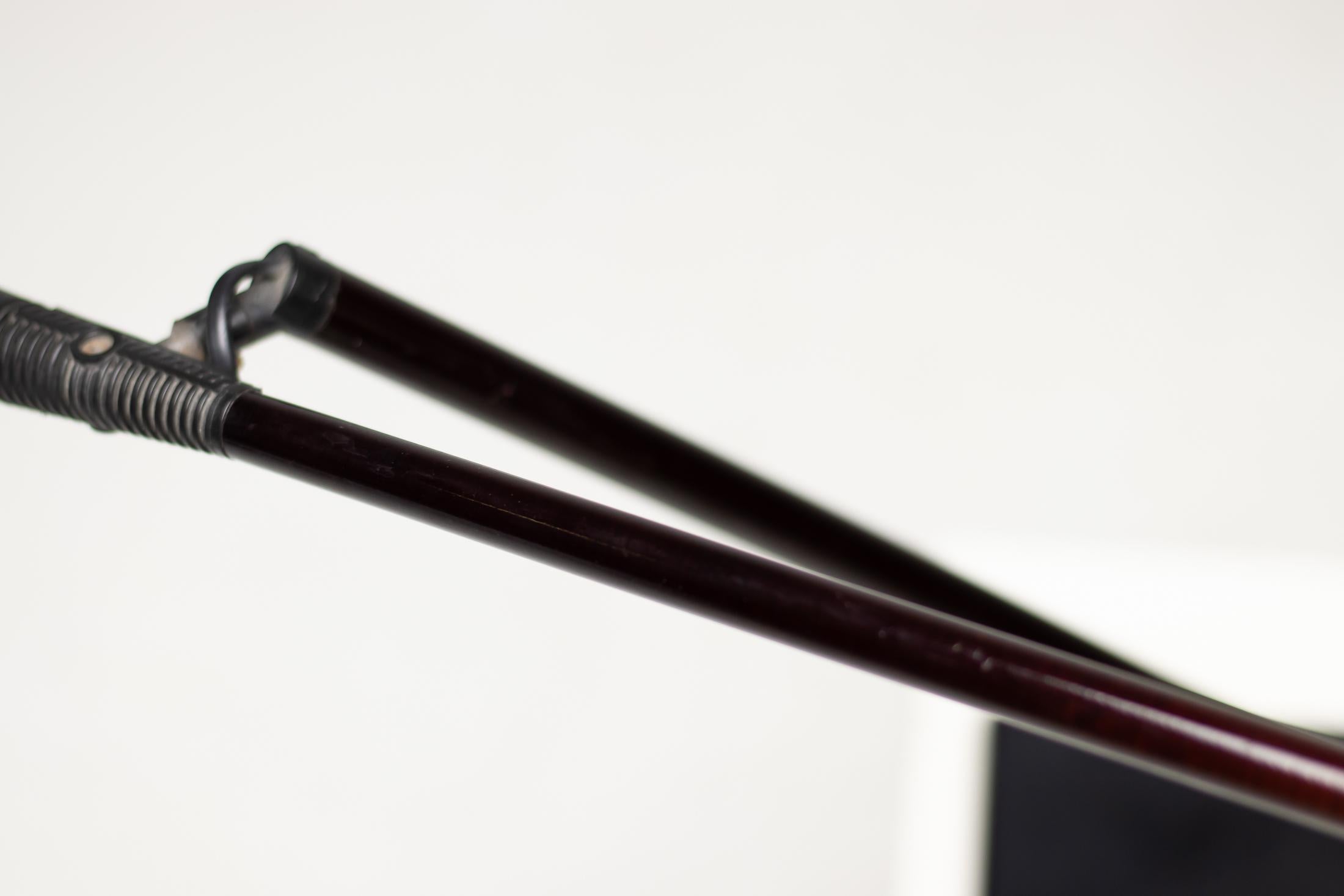 The balanced arm is made of dark red fiberglass to be as light as possible and consequently reduce the counterweight. 
The joint allows the arm to move both on the vertical and on the horizontal plane. The polycarbonate moulded reflector rotates on