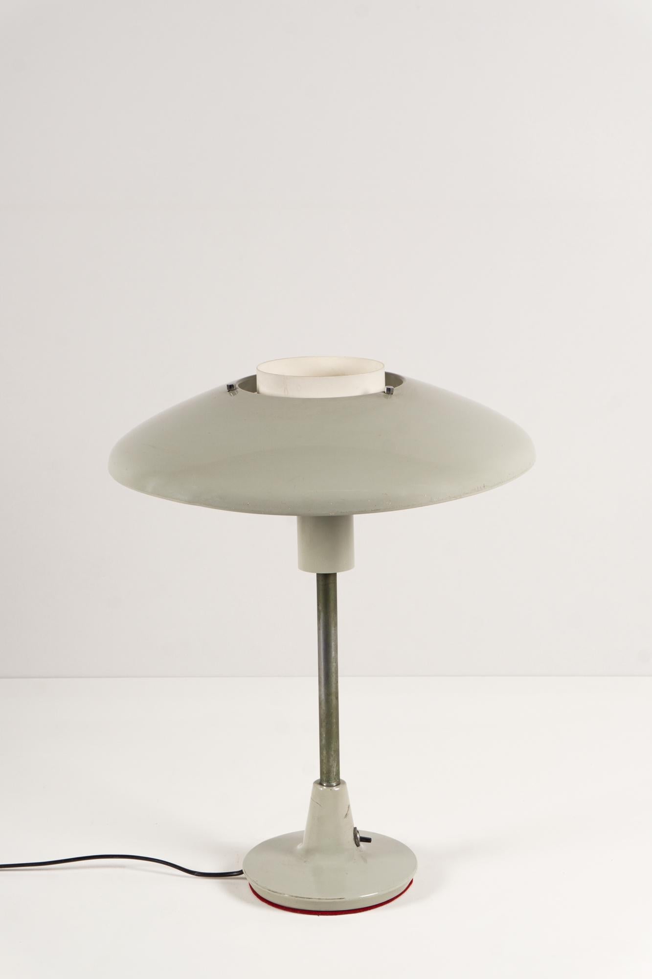 Cette magnifique lampe de table gris clair modèle '8022' a été produite vers 1958 par Stilnovo.
Fabriquée en aluminium, la base et le réflecteur sont peints en gris clair / blanc. La lampe est équipée d'un interrupteur à bascule sur le côté.