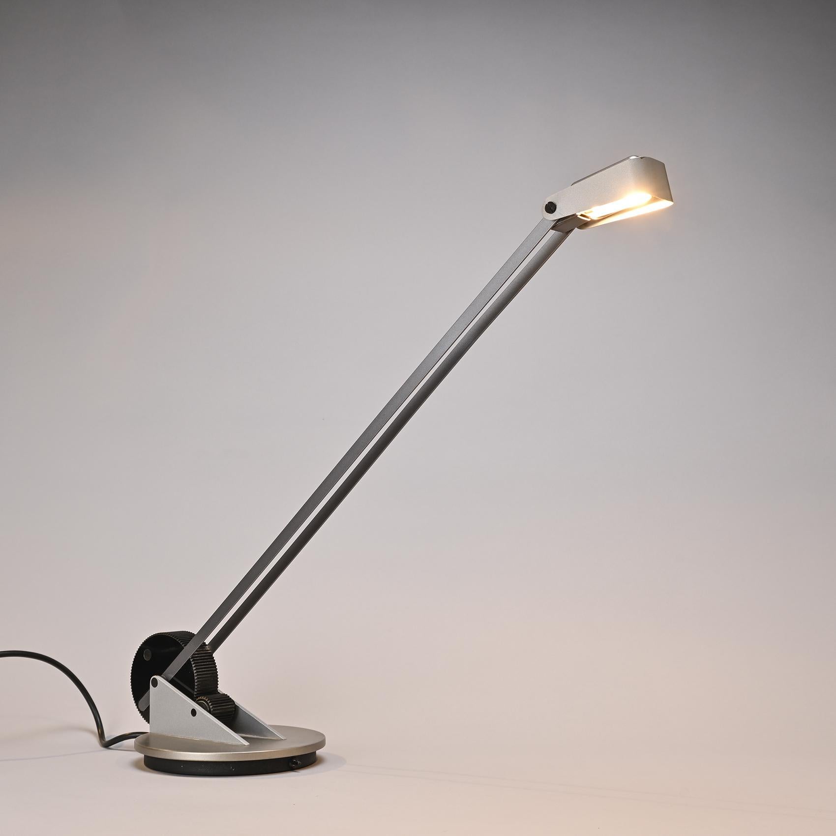 Rare lampe de table, modèle Meccanica, conçue par le designer italien Michele de Lucchi.

La base circulaire supporte deux bras qui soutiennent un réflecteur pivotant, fabriqué en métal laqué gris ;

Fabricant : Belux, circa 1986.

Produit à Wohlen,