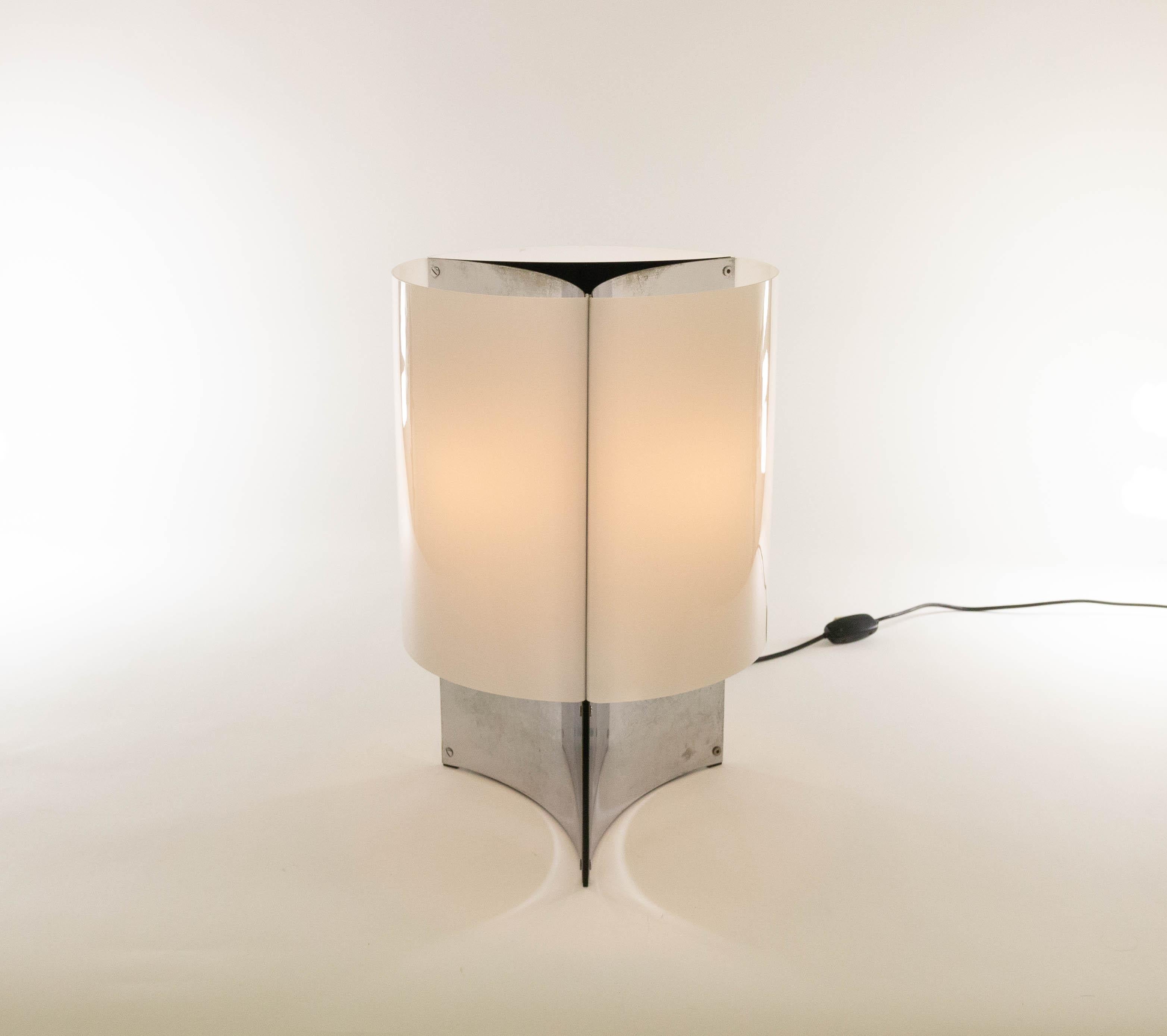This elegant lamp model 526 was designed in 1965 by Massimo Vignelli for Italian lighting manufacturer Arteluce.

Model 526 is a table lamp with a base that consists of three concave chromed sheets. This base is covered by white Perspex shades. It