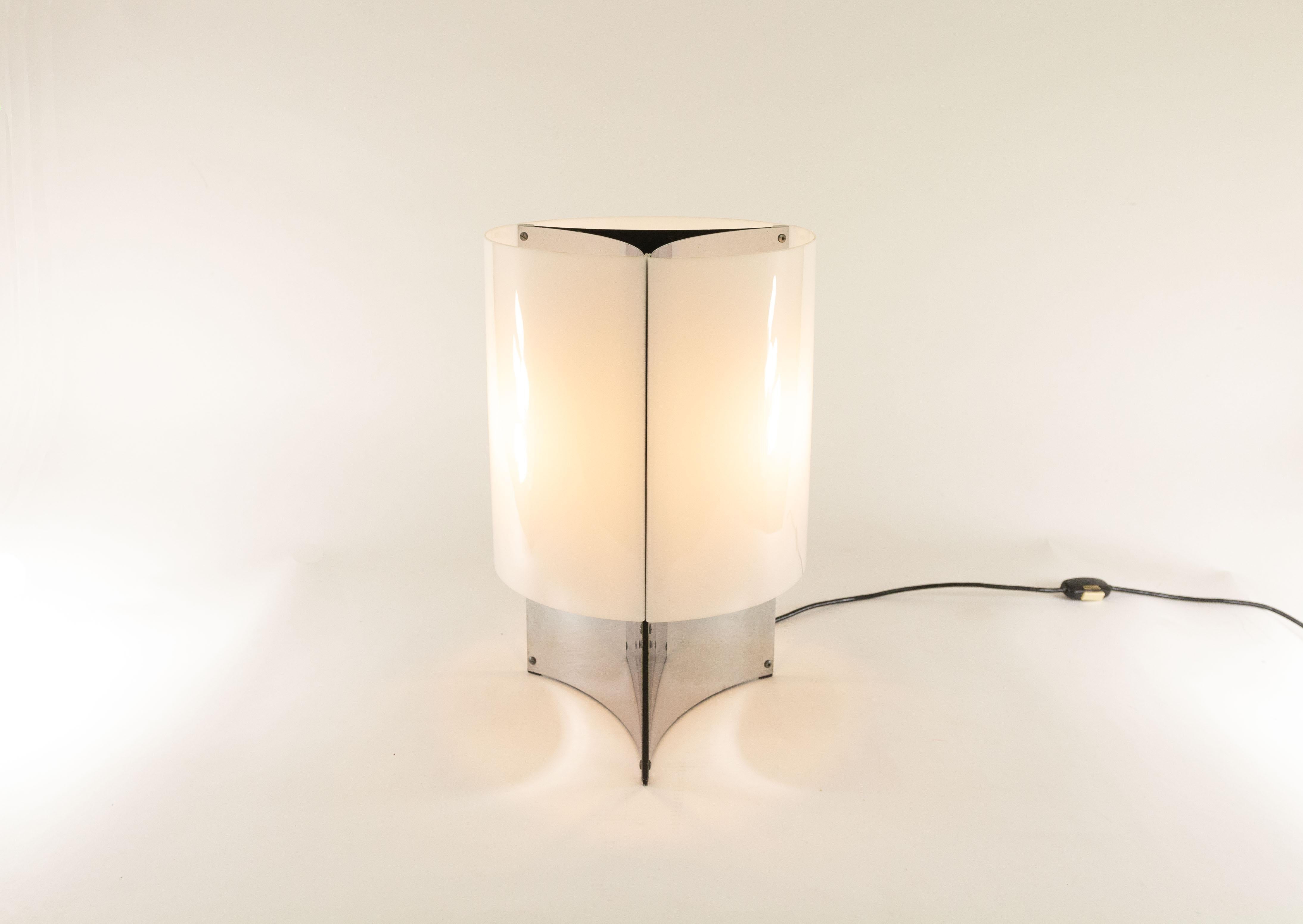 This elegant lamp model No. 526/P was designed in 1965 by Massimo Vignelli for Italian lighting manufacturer Arteluce.

Model No. 526 is a table lamp with a base that consists of three concave chromed sheets. This base is covered by white Perspex