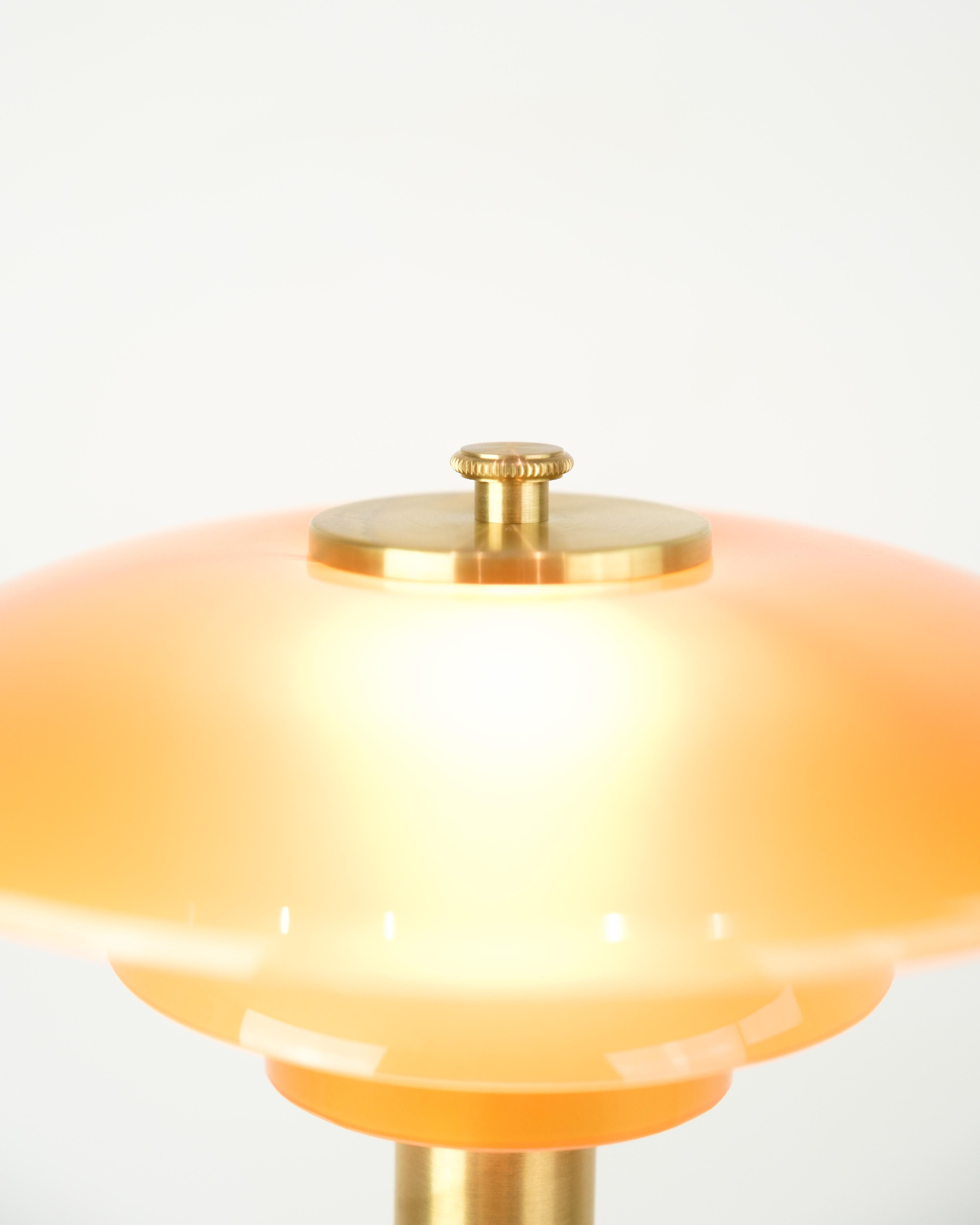 Lampe de table PH, modèle PH 2/1, conçue par Poul Henningsen et produite par Louis Poulsen en édition limitée. La lampe est en laiton avec des abat-jours en verre ambré soufflé à la bouche qui fournissent une lumière chaude et agréable.

La lampe