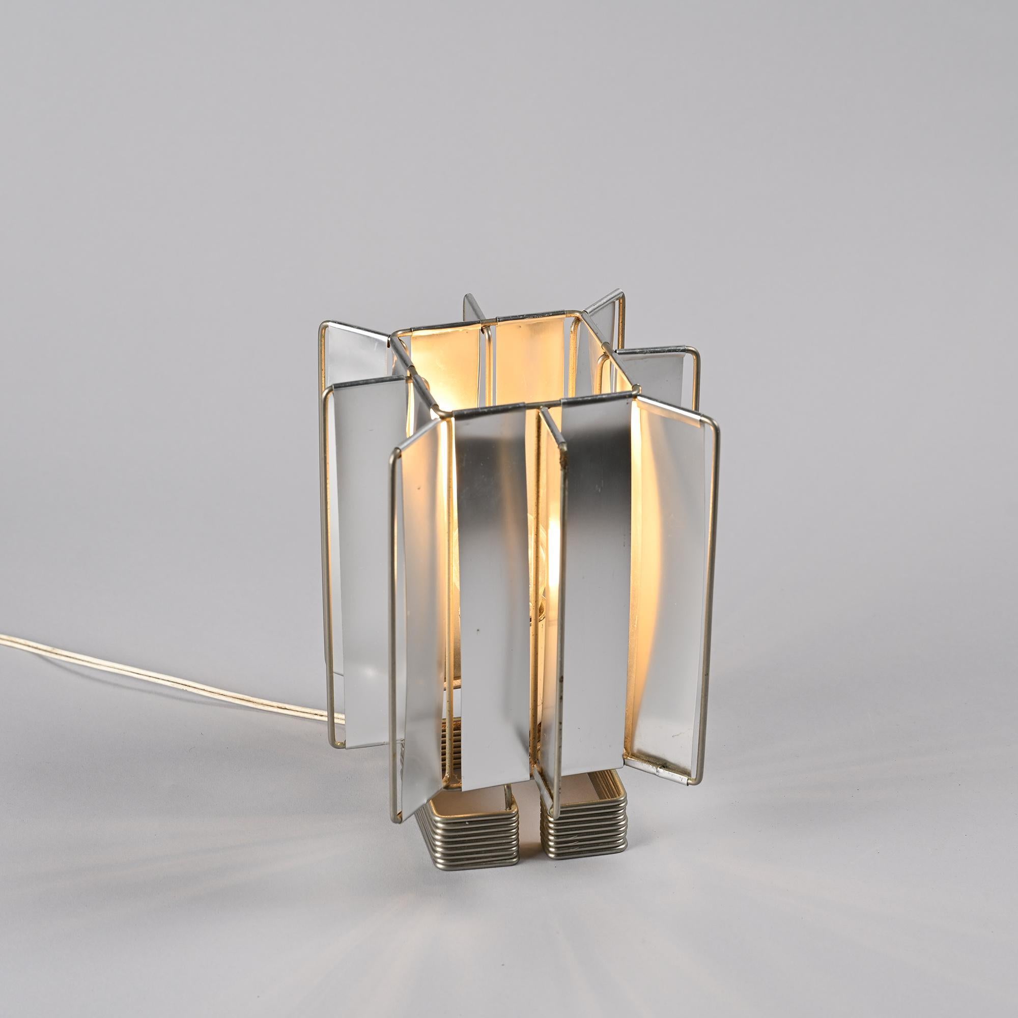 
The Sirius table lamp features a base made of two parts constructed from aluminum wires, supporting a finned wireframe structure.

This lamp masterfully plays with light and shadows, creating a unique and modern atmosphere. Its minimalist design
