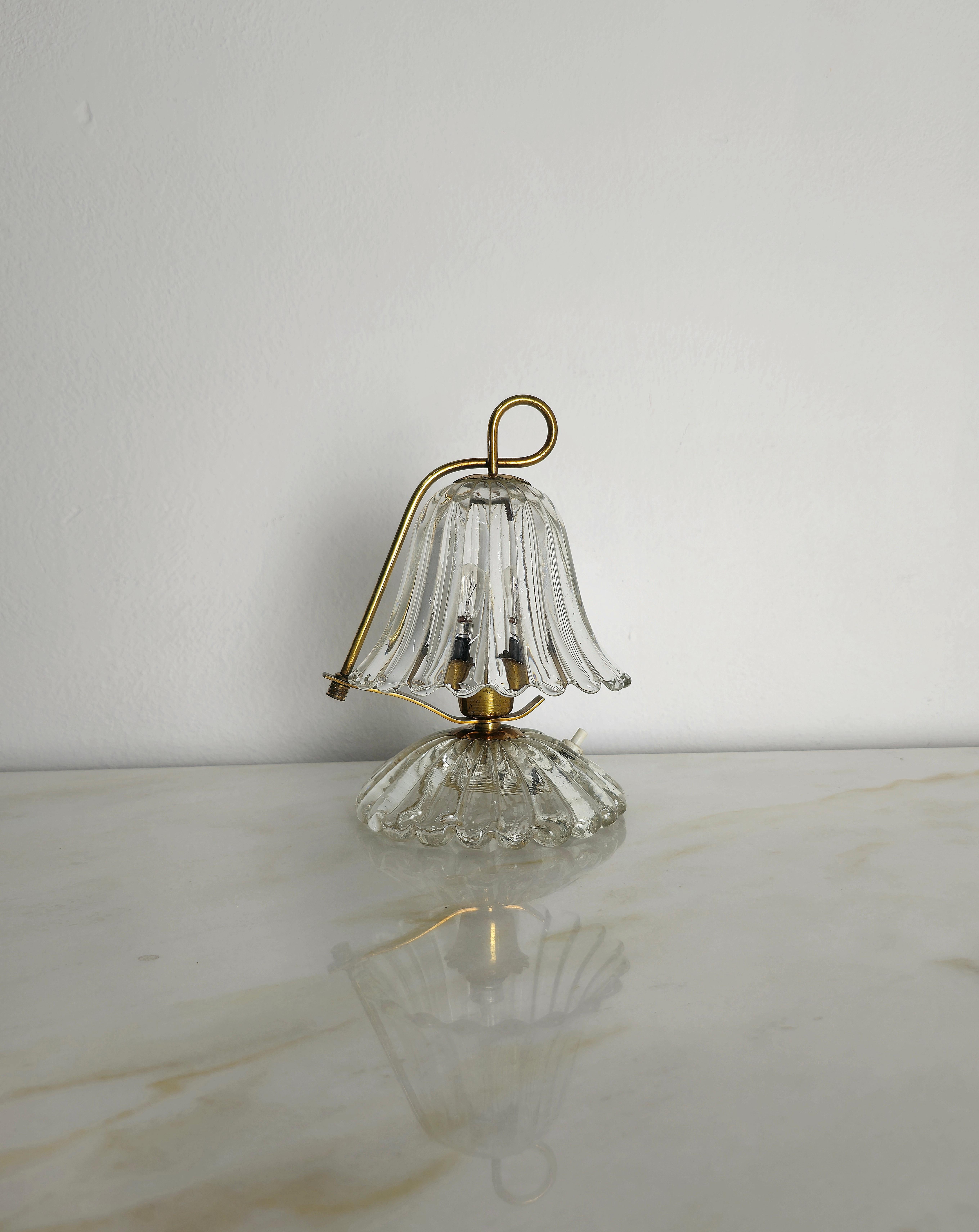 Kleine Tischlampe, die in den 1940er Jahren von Barovier und Toso in Italien hergestellt wurde.
Die Tischleuchte ist aus Messing und Murano-Glas gefertigt, mit der Besonderheit, dass das obere Glas nach rechts oder links verstellbar ist, wie im