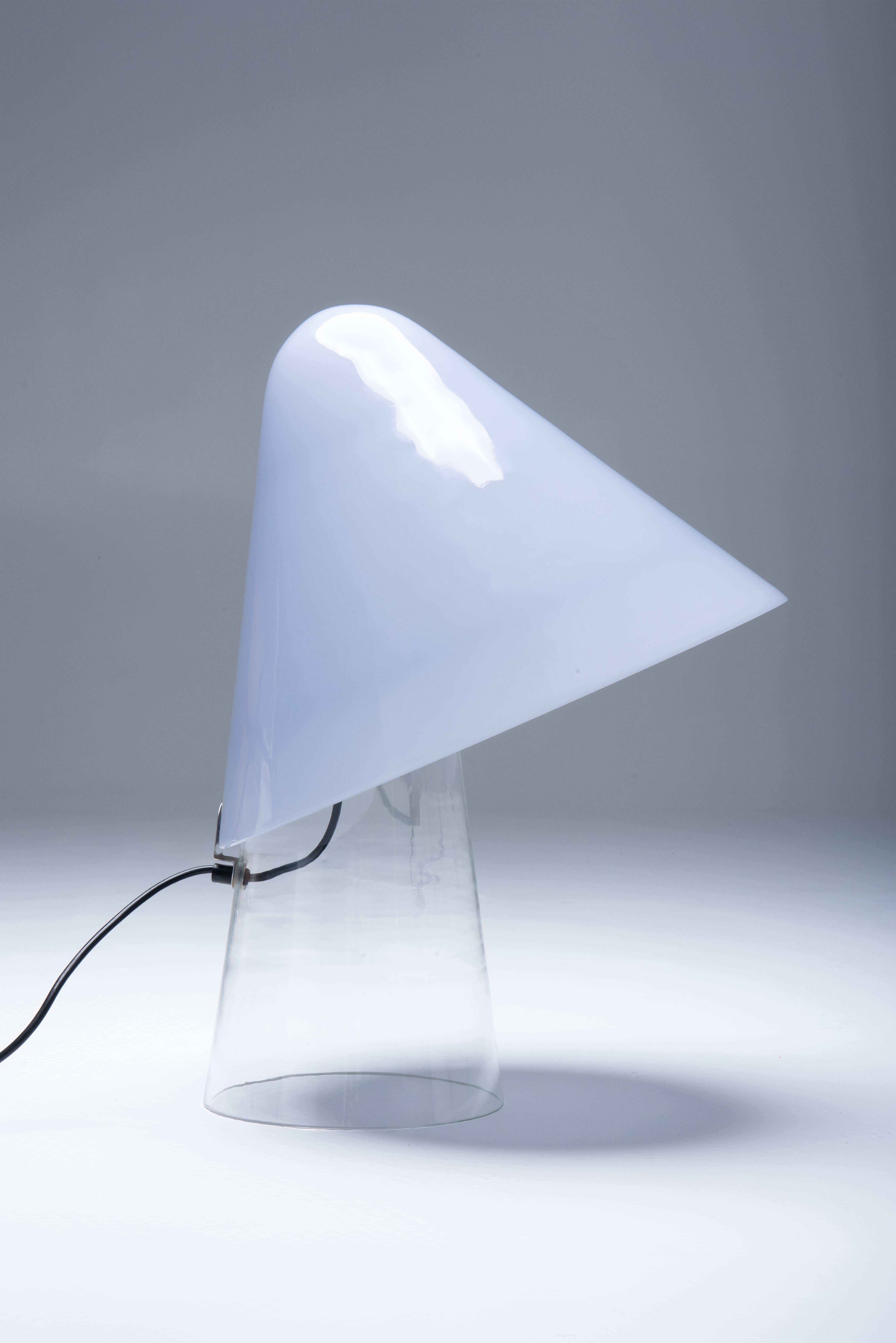 Lámpara de sobremesa de cristal de Murano diseñada por Mauro Marzello para Mazzega a finales de los años 70 y principios de los 80.. Un diseño maravillosamente sofisticado en el que la base es de cristal transparente. La pantalla es de cristal de
